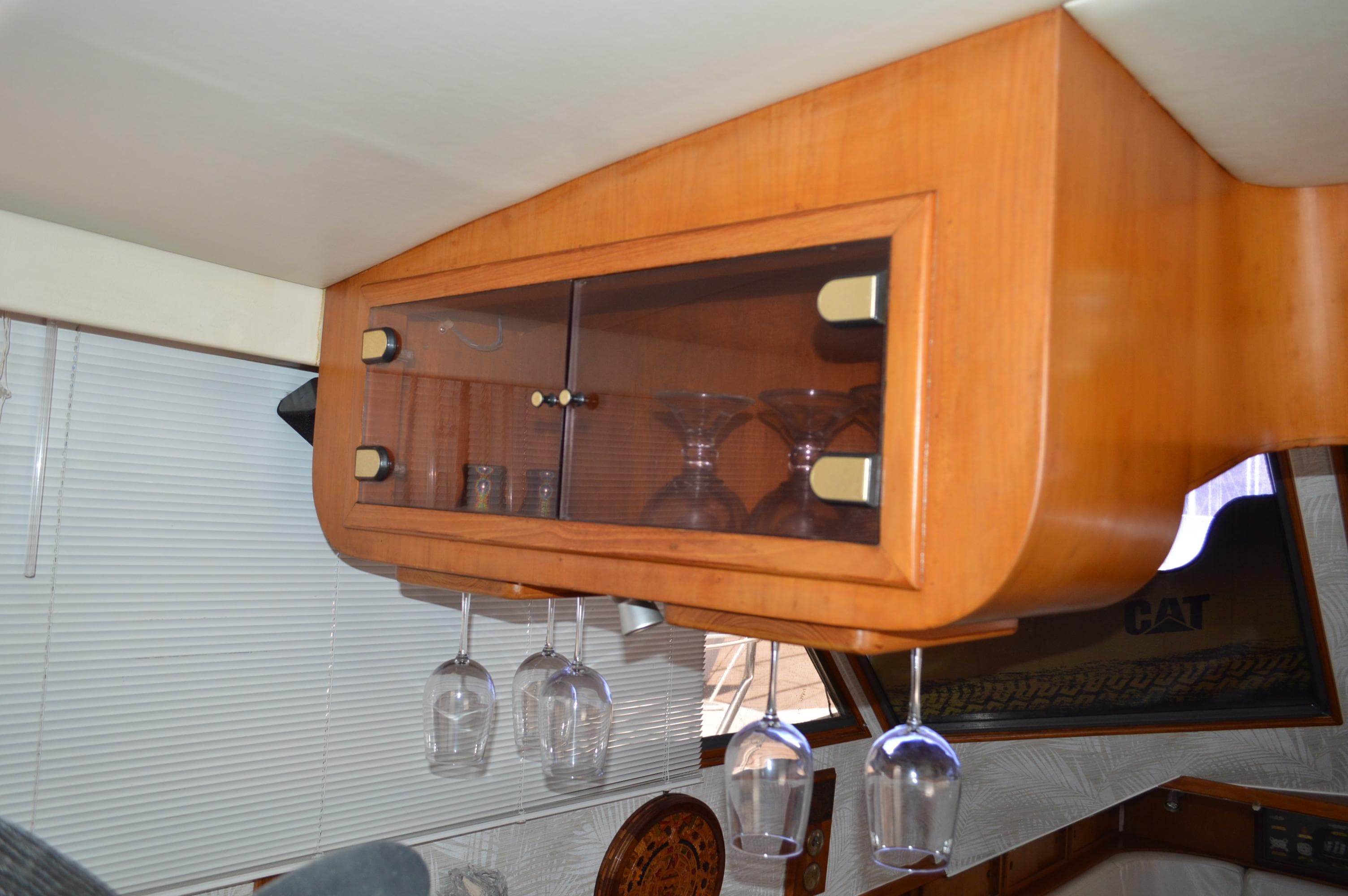 Wooden cabinet with glassware in a 1987 Symbol 51 yacht interior.