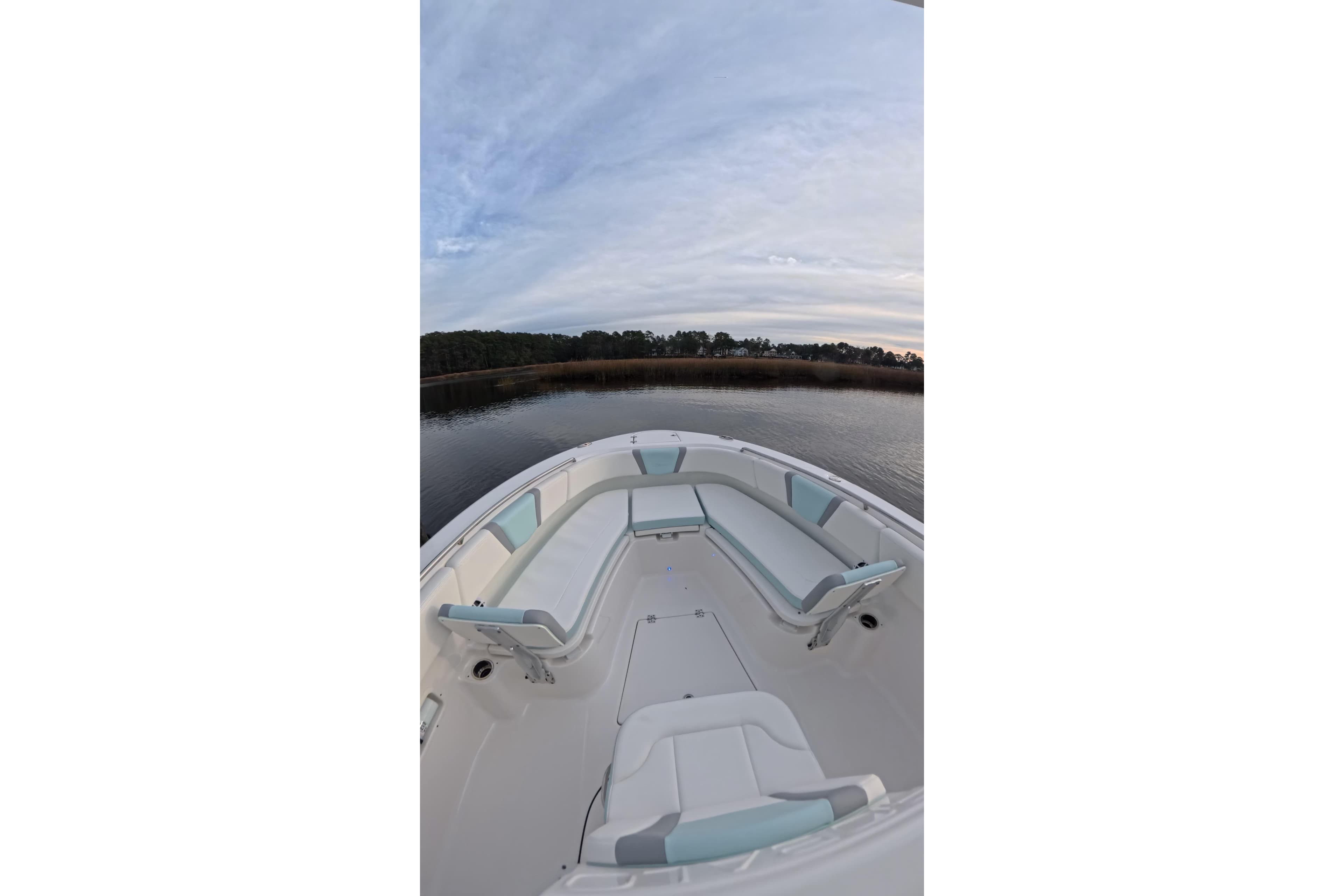 Robalo R250 Center Console 2025 on calm water at sunset.