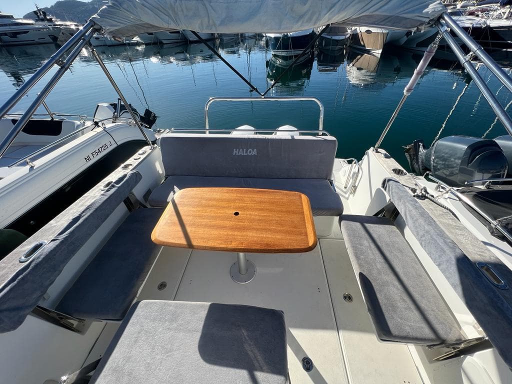2017 Beneteau Flyer 8.8 Sundeck boat interior with seating and wooden table in marina.
