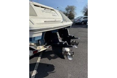 Rear view of a 2000 Formula boat with dual propellers in a parking lot.