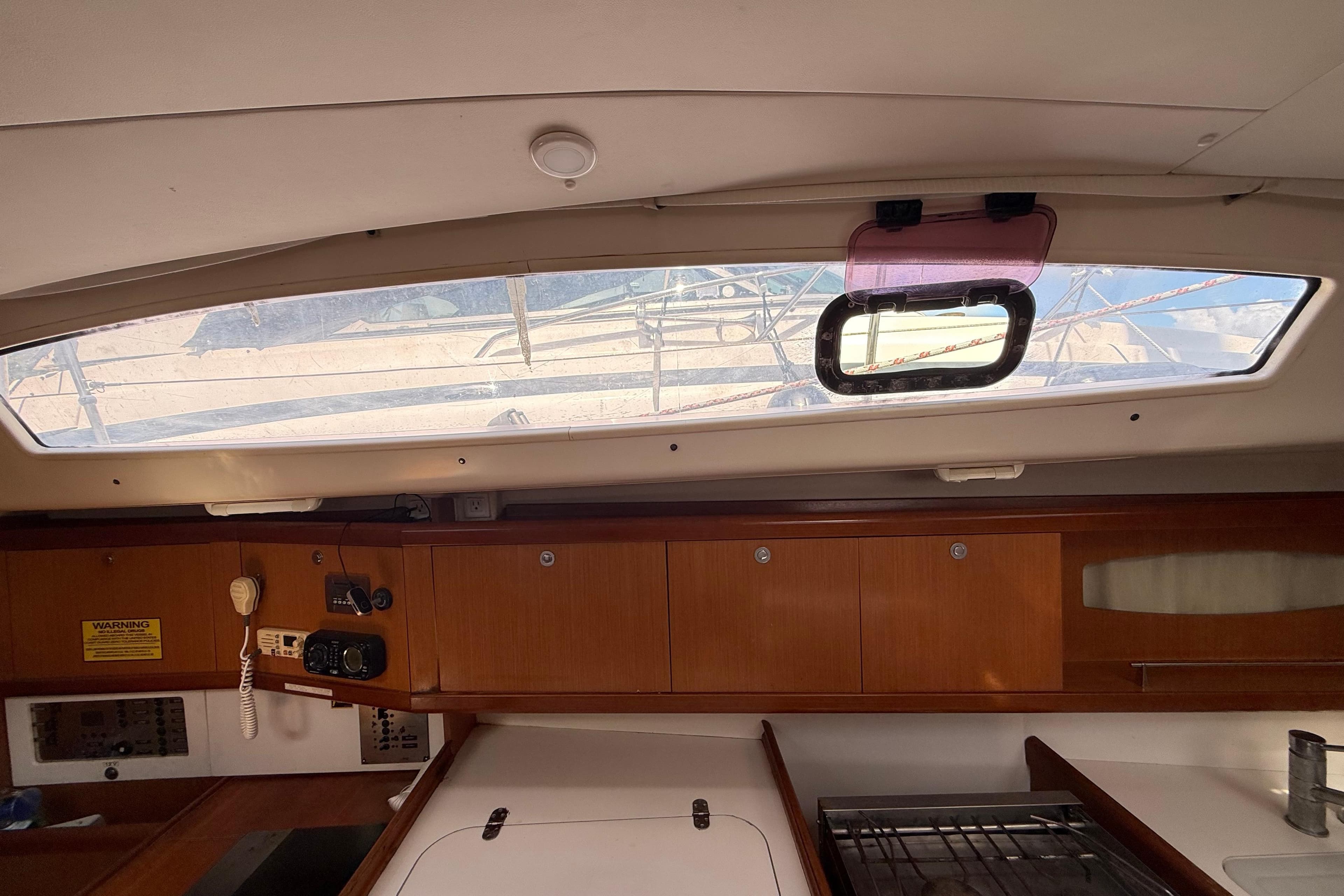 Interior view of 2009 Beneteau Oceanis 40 sailboat, featuring wooden cabinetry and a window.
