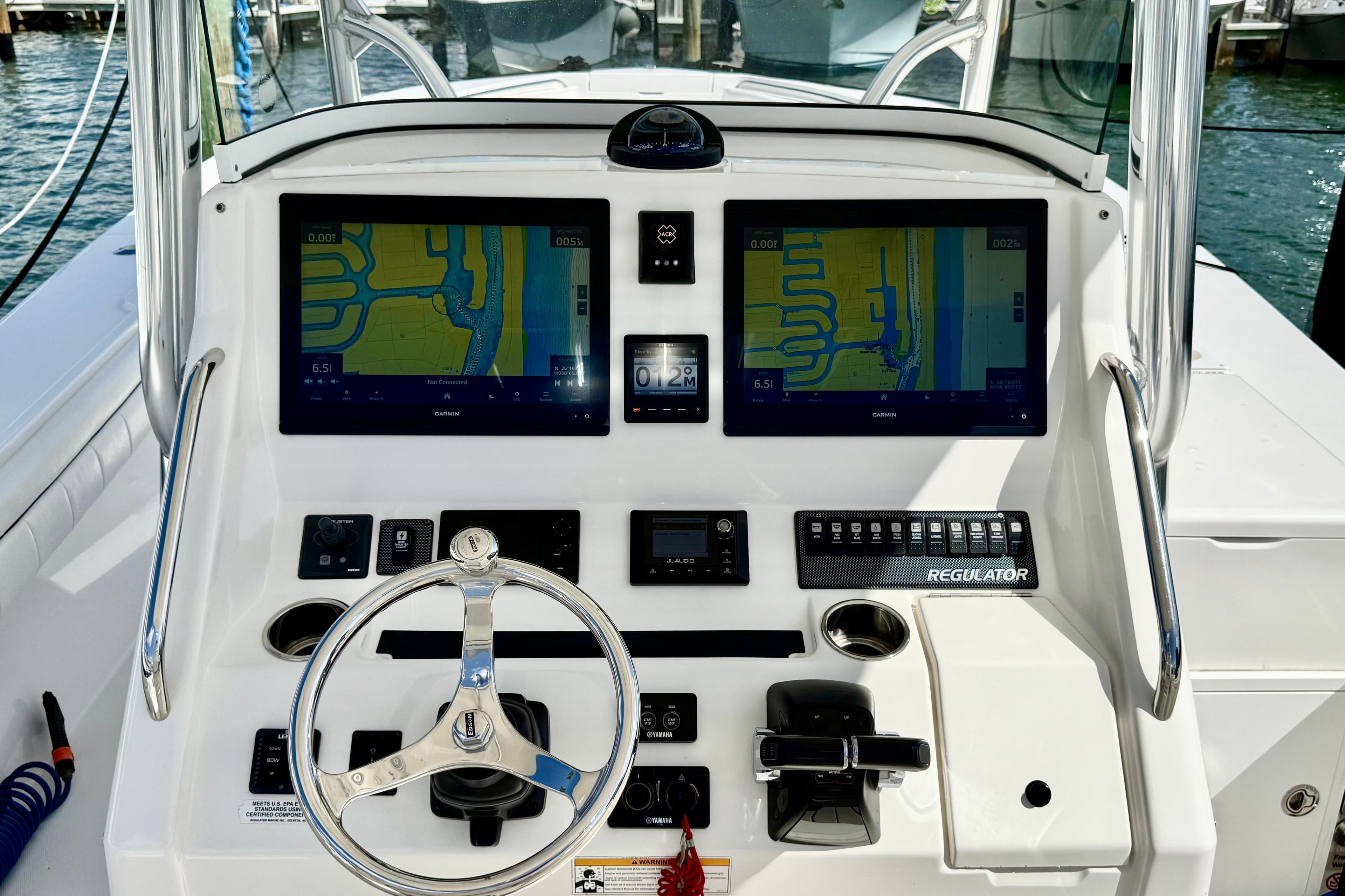 2016 Regulator 34SS boat dashboard with dual Garmin displays and steering wheel.