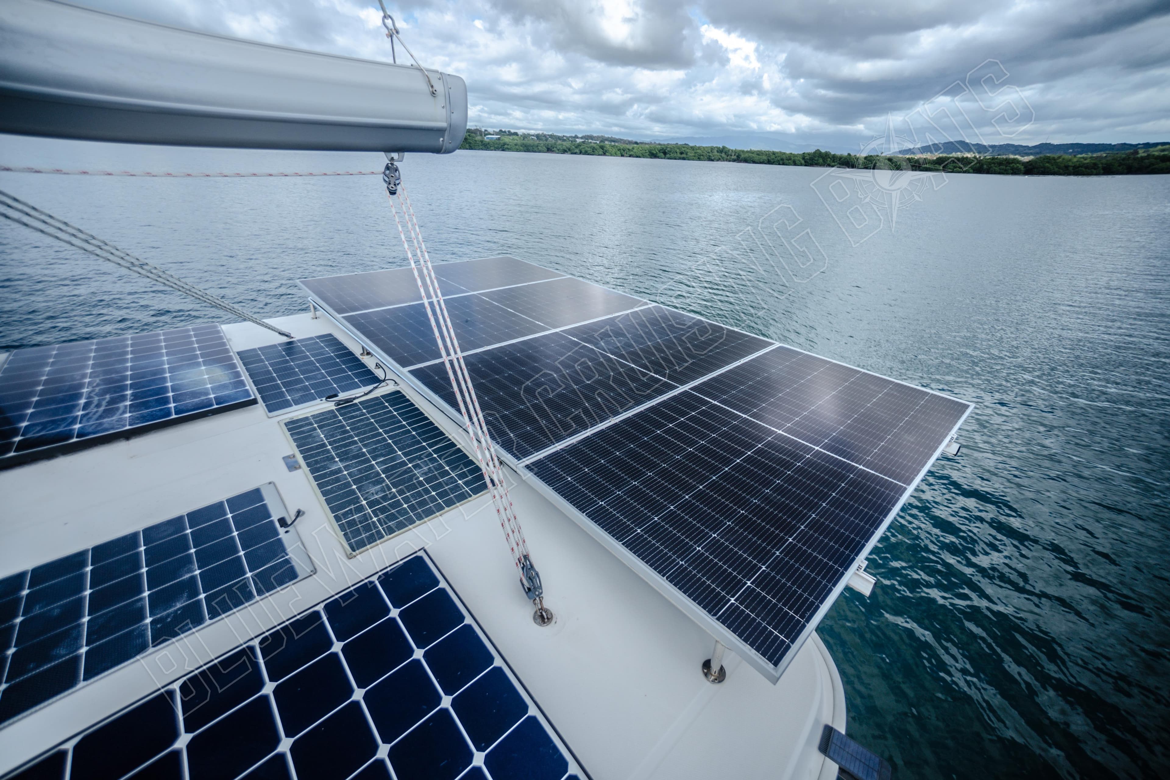 Solar panels on a 2015 Leopard 48 yacht, sailing on a calm lake under cloudy skies.