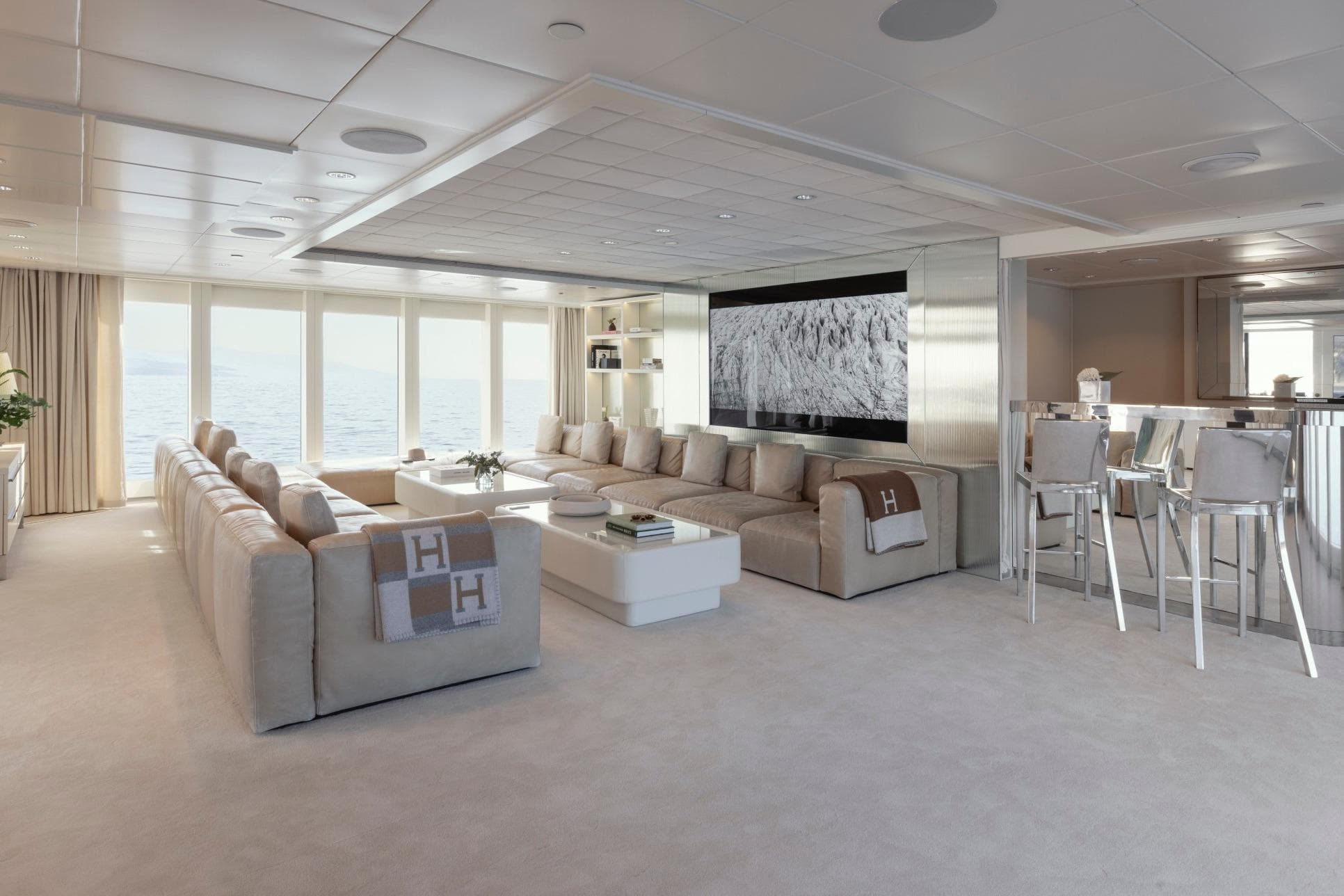 Luxurious yacht interior with beige sofas, large windows, and modern decor, Austal Displacement 2007.