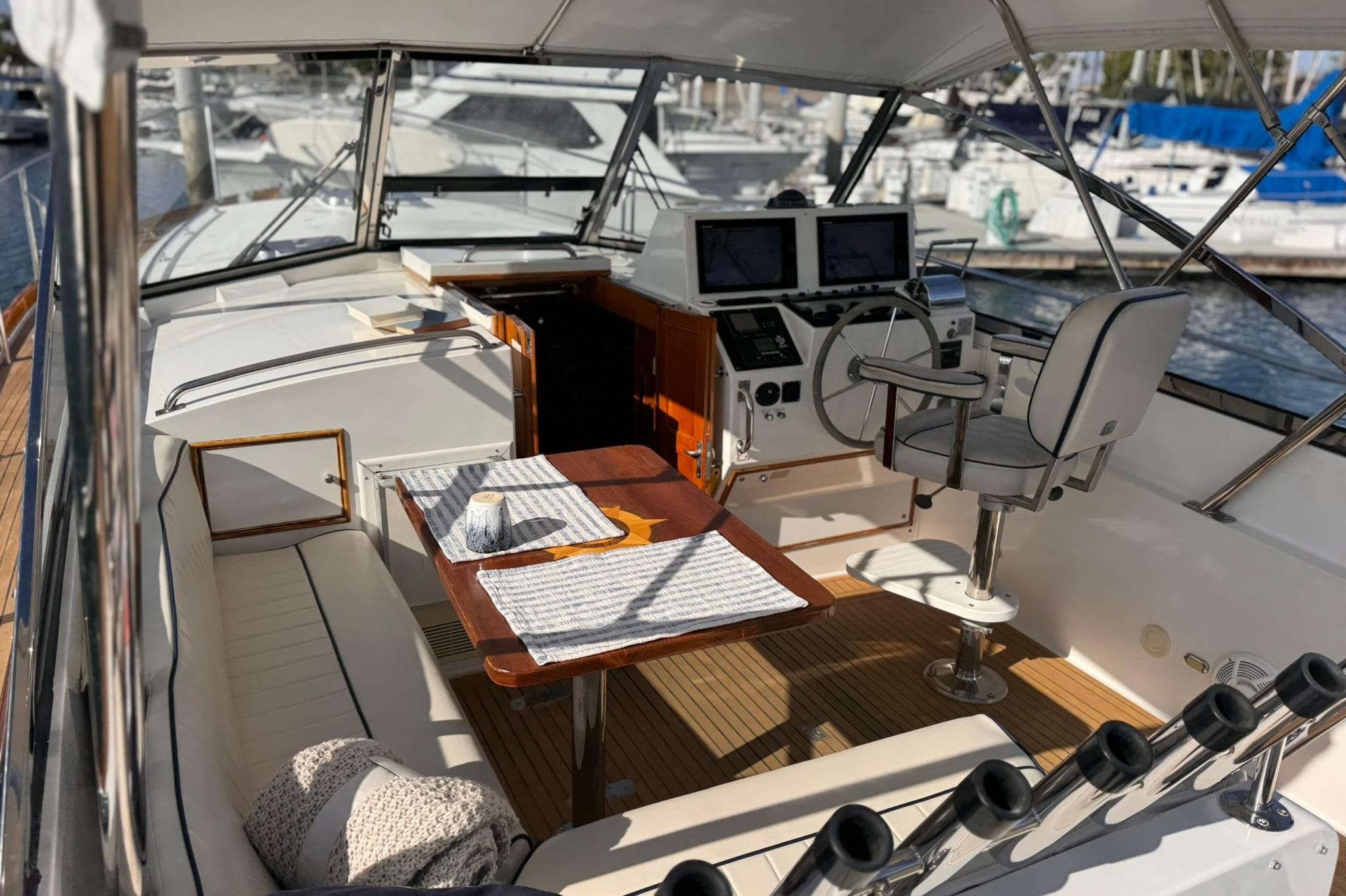 1999 Grand Banks 38 Eastbay EX yacht interior with helm, seating, and table at marina.