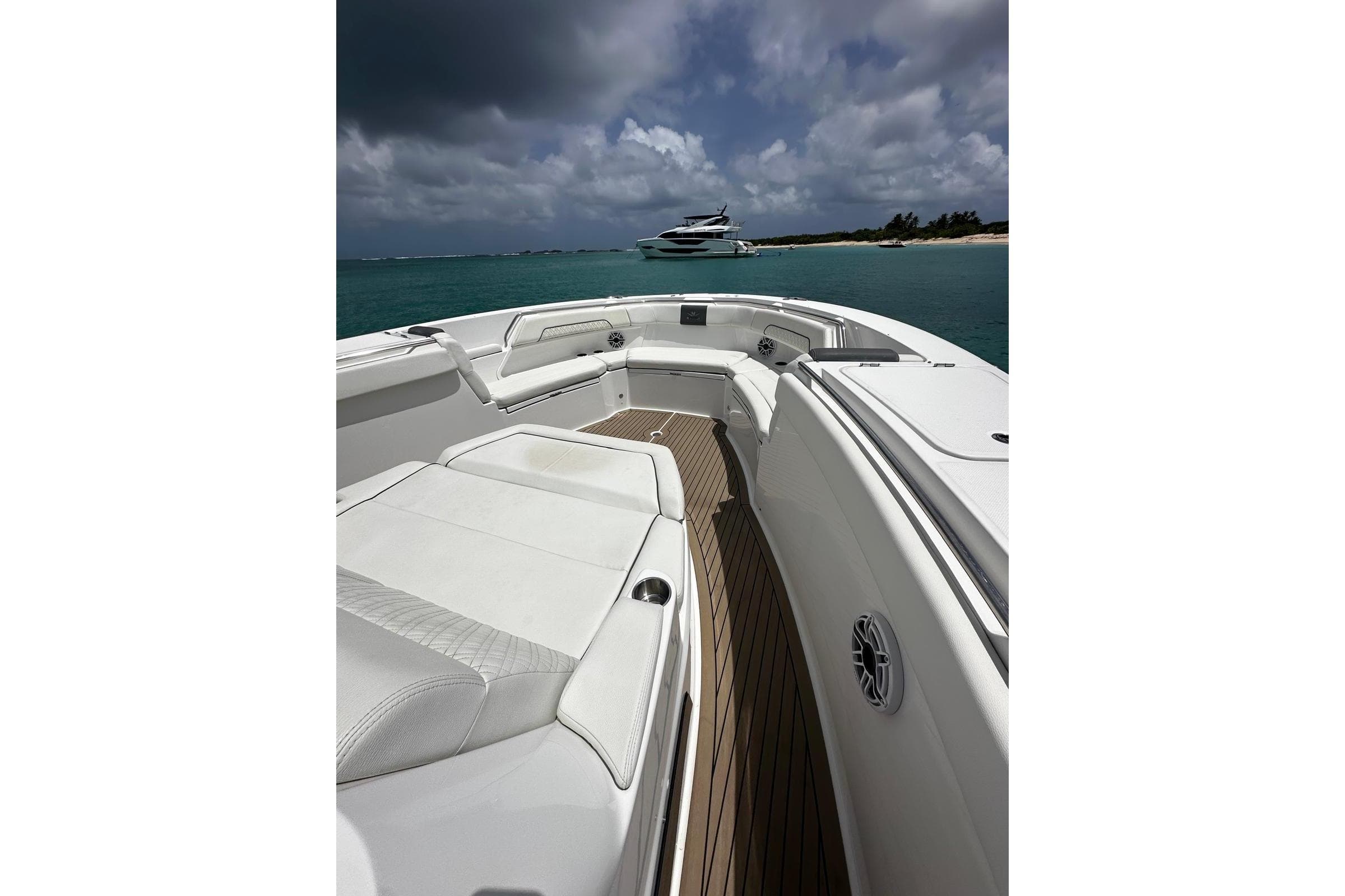 2022 Bertram 39 CC boat interior with white seating, ocean view, and cloudy sky.