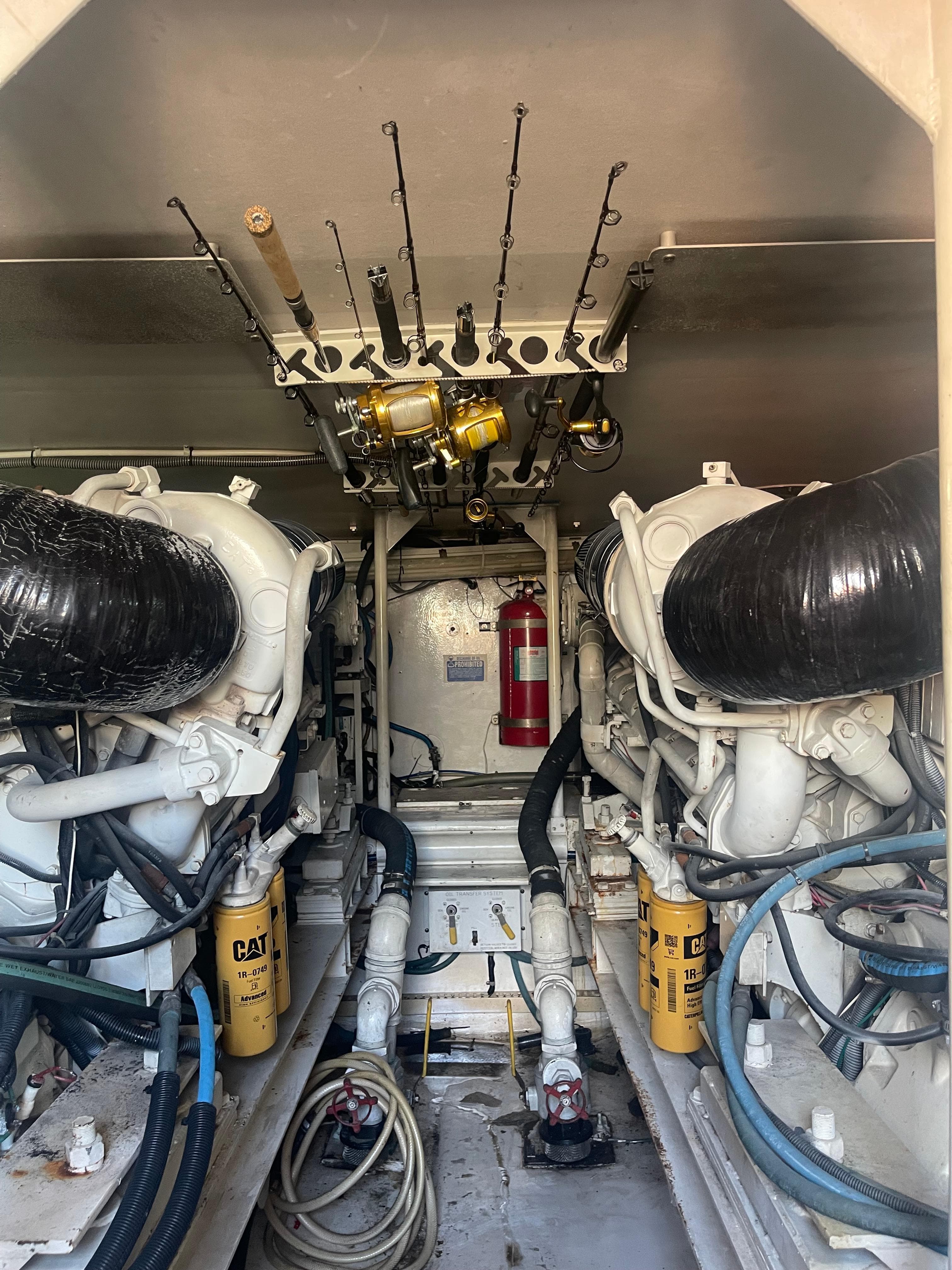 Engine room of 1999 Viking 58 EB yacht with fishing rods and equipment.
