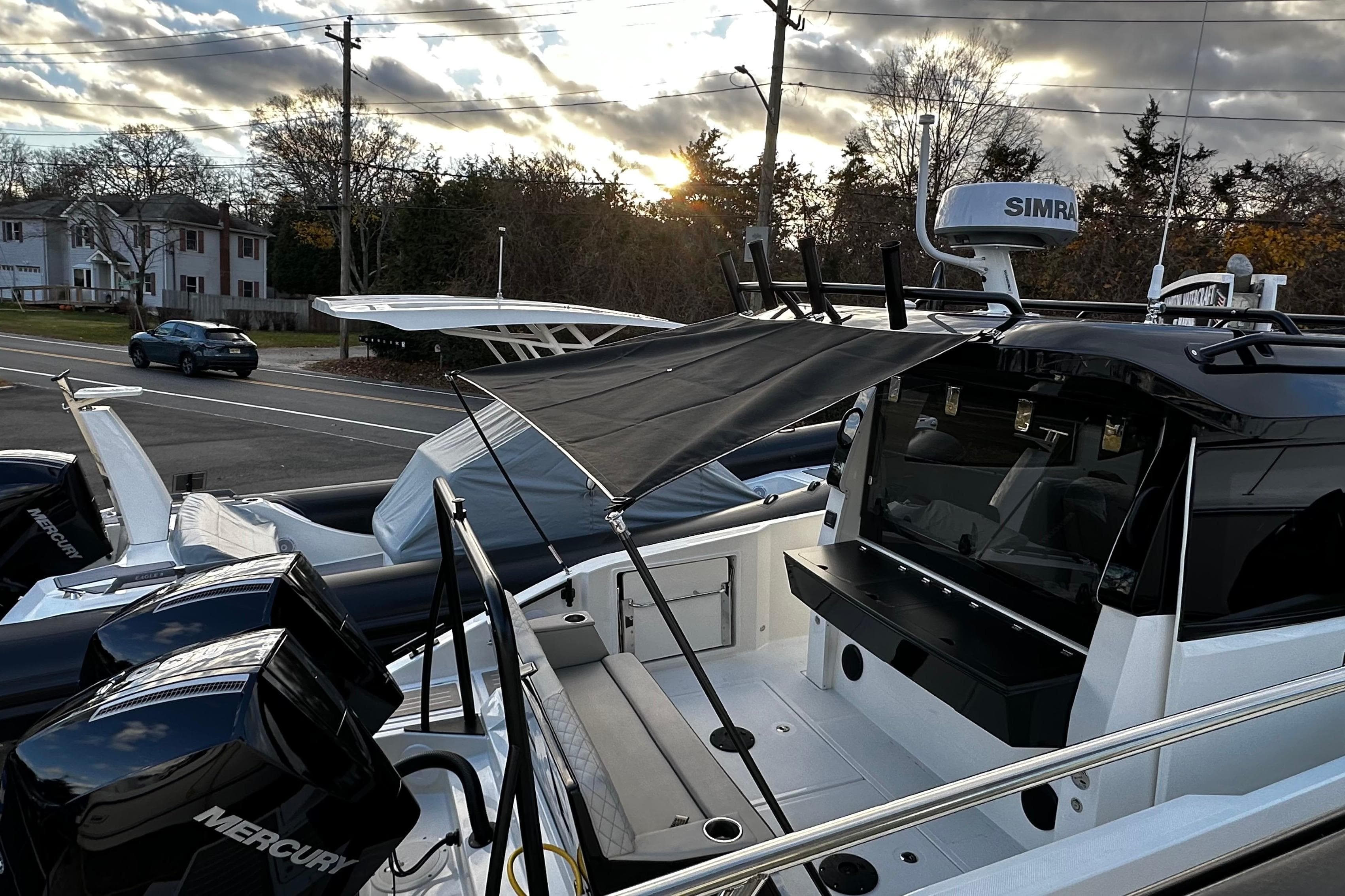 2026 Navan C30 boat with Mercury engines, parked near a road at sunset.