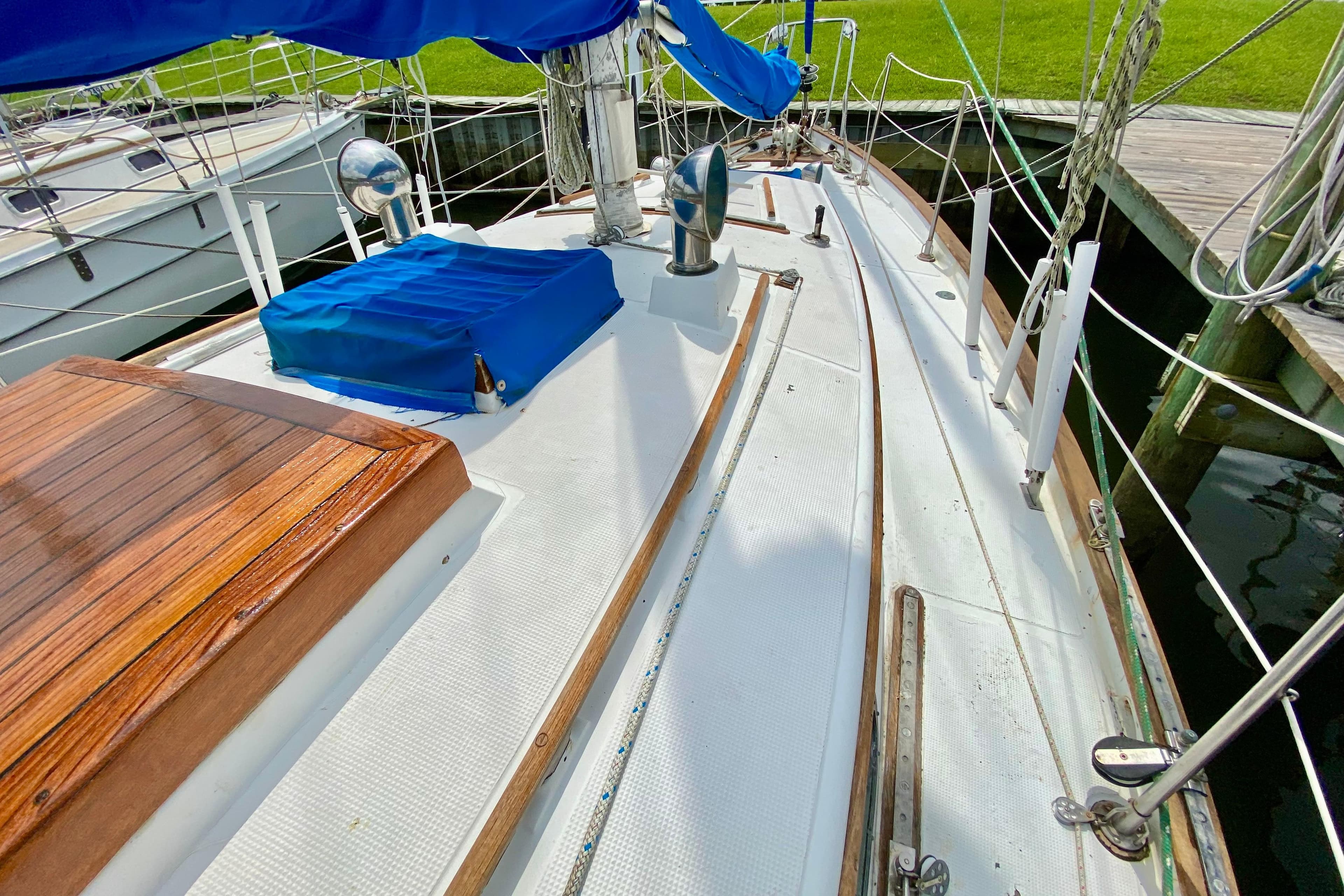 1981 Union EO 32 sailboat deck with blue cover, docked at marina.