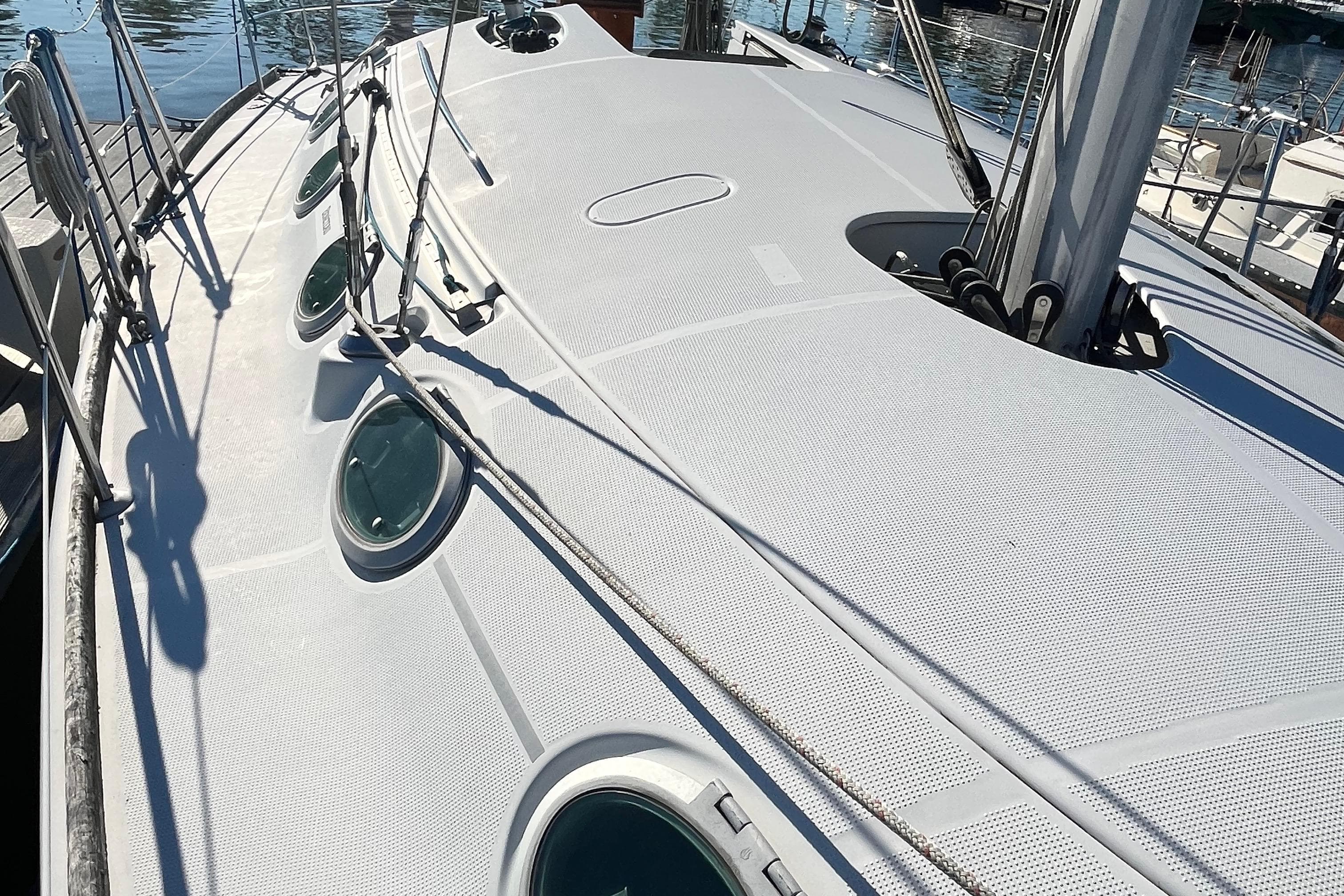 Deck view of a 1994 Beneteau First 35s7 sailboat, featuring sleek design and portholes.