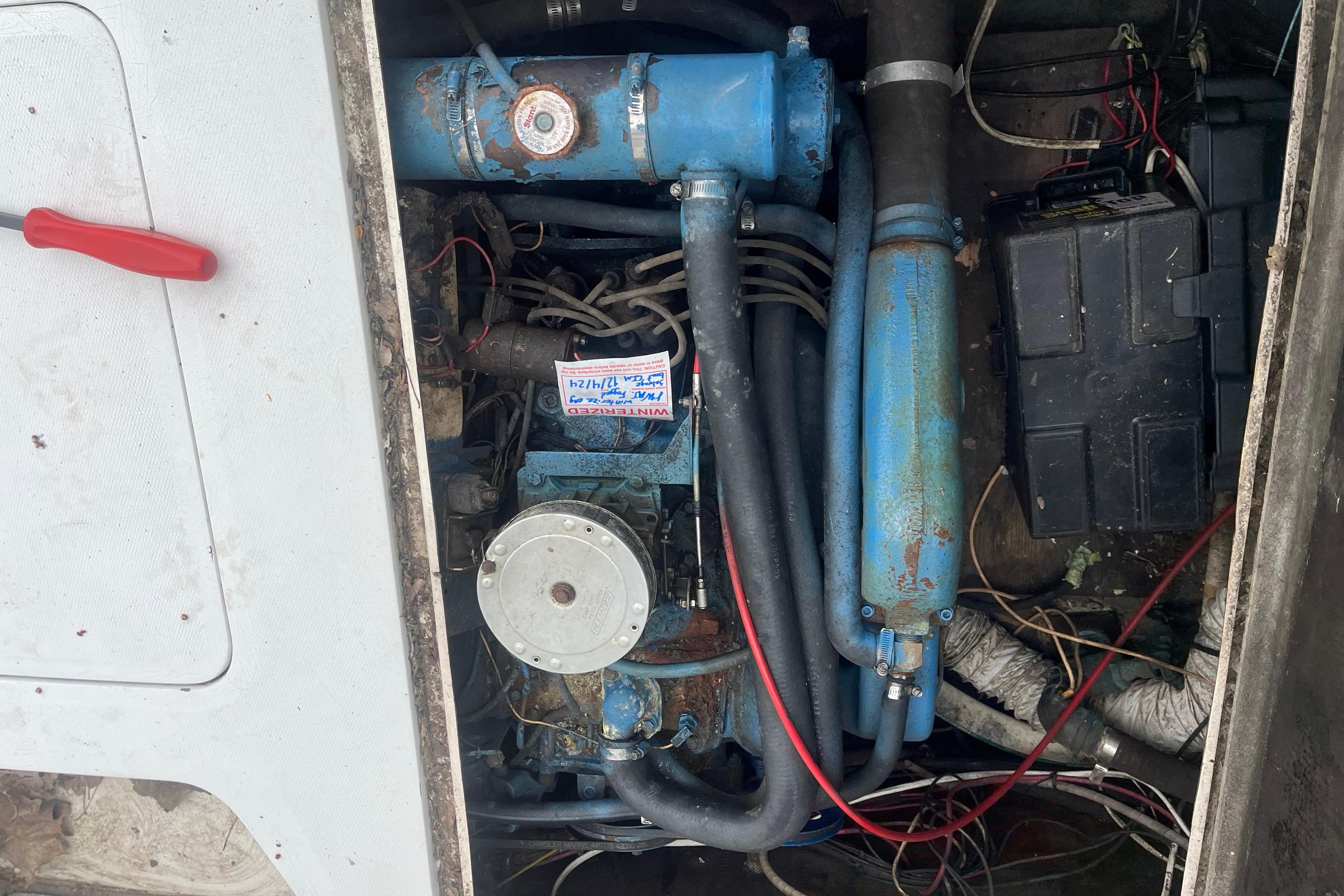 Engine compartment of a 1973 Bertram 28 Flybridge Cruiser with visible wiring and components.