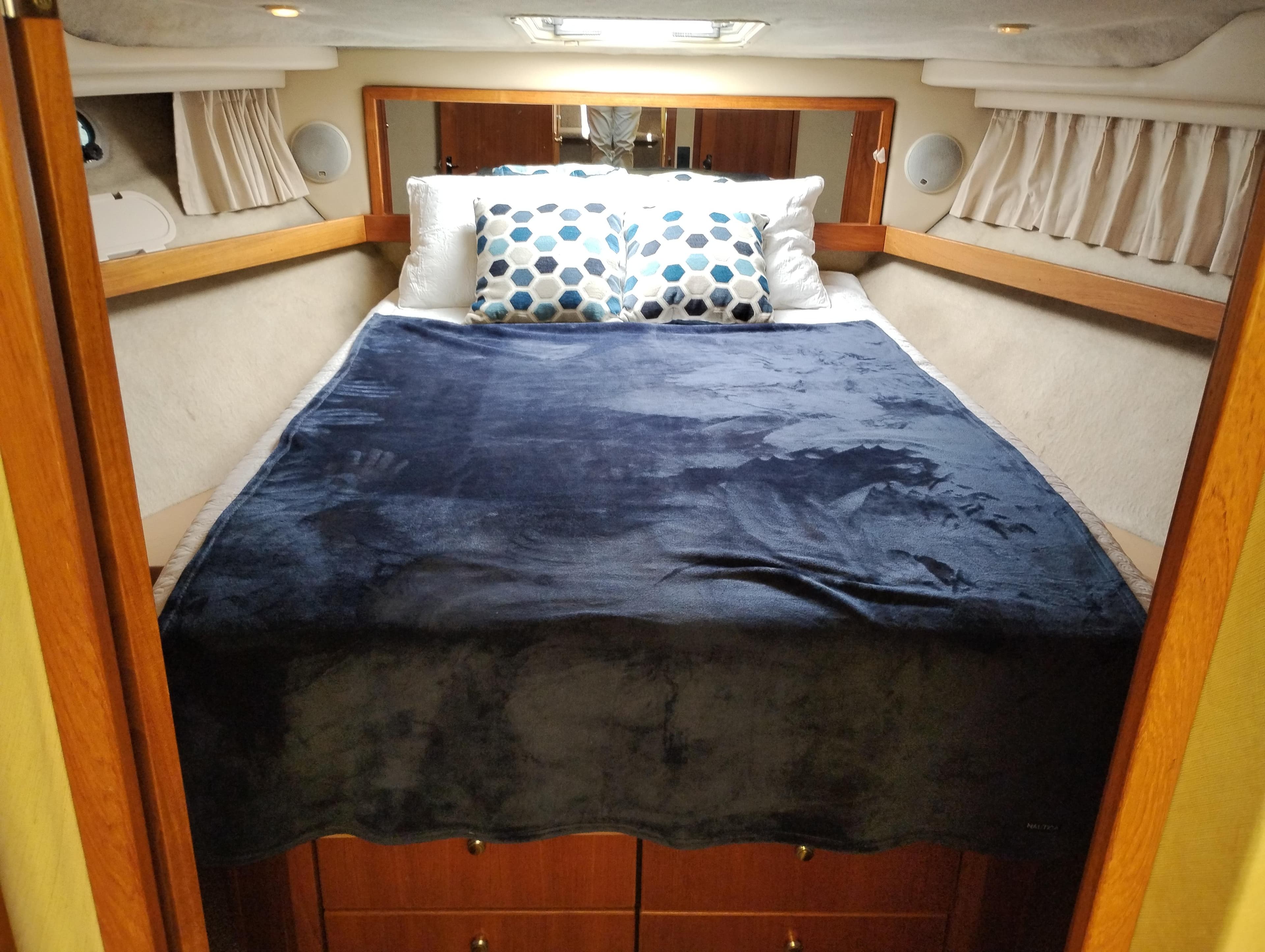 Cozy bedroom in 1997 Bayliner 3988 Motor Yacht with plush bedding and wooden accents.