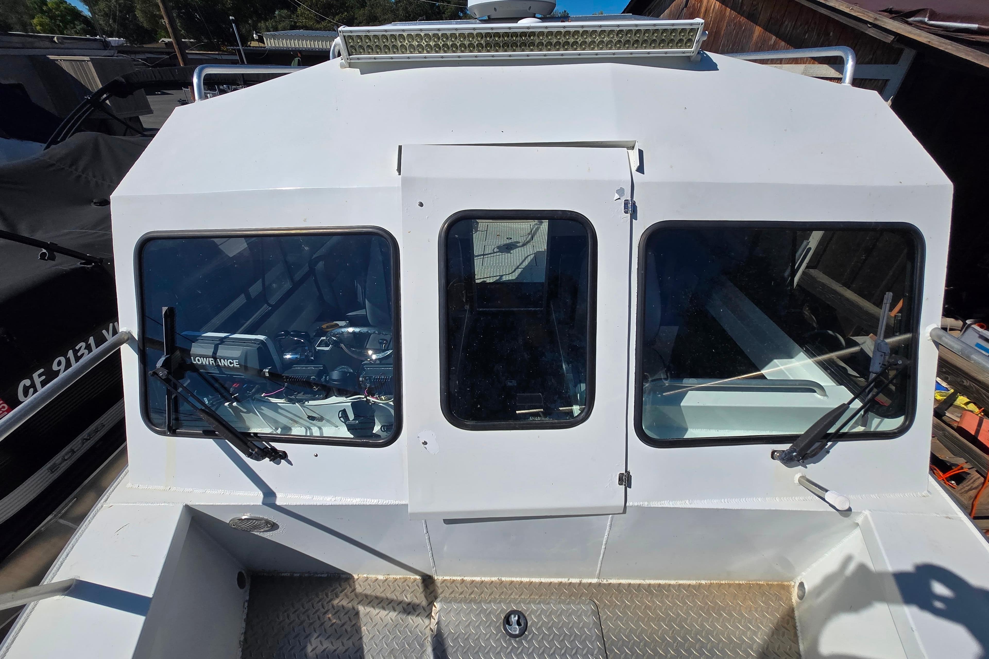 2020 Raider 250 Sea Raider boat with windshield and wipers, docked outdoors.
