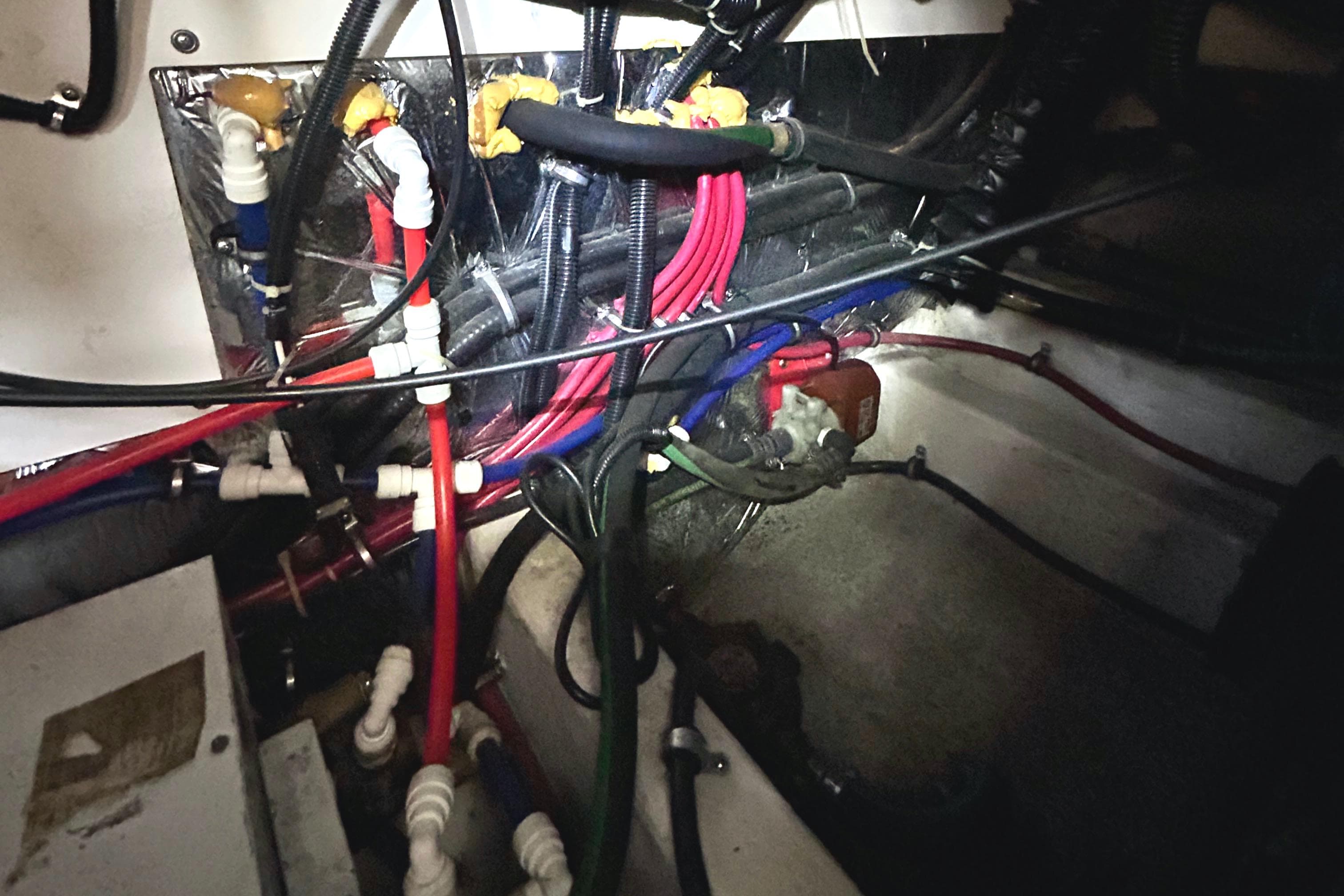 Wiring and plumbing in the engine compartment of a 1998 Pursuit 3000 Offshore boat.