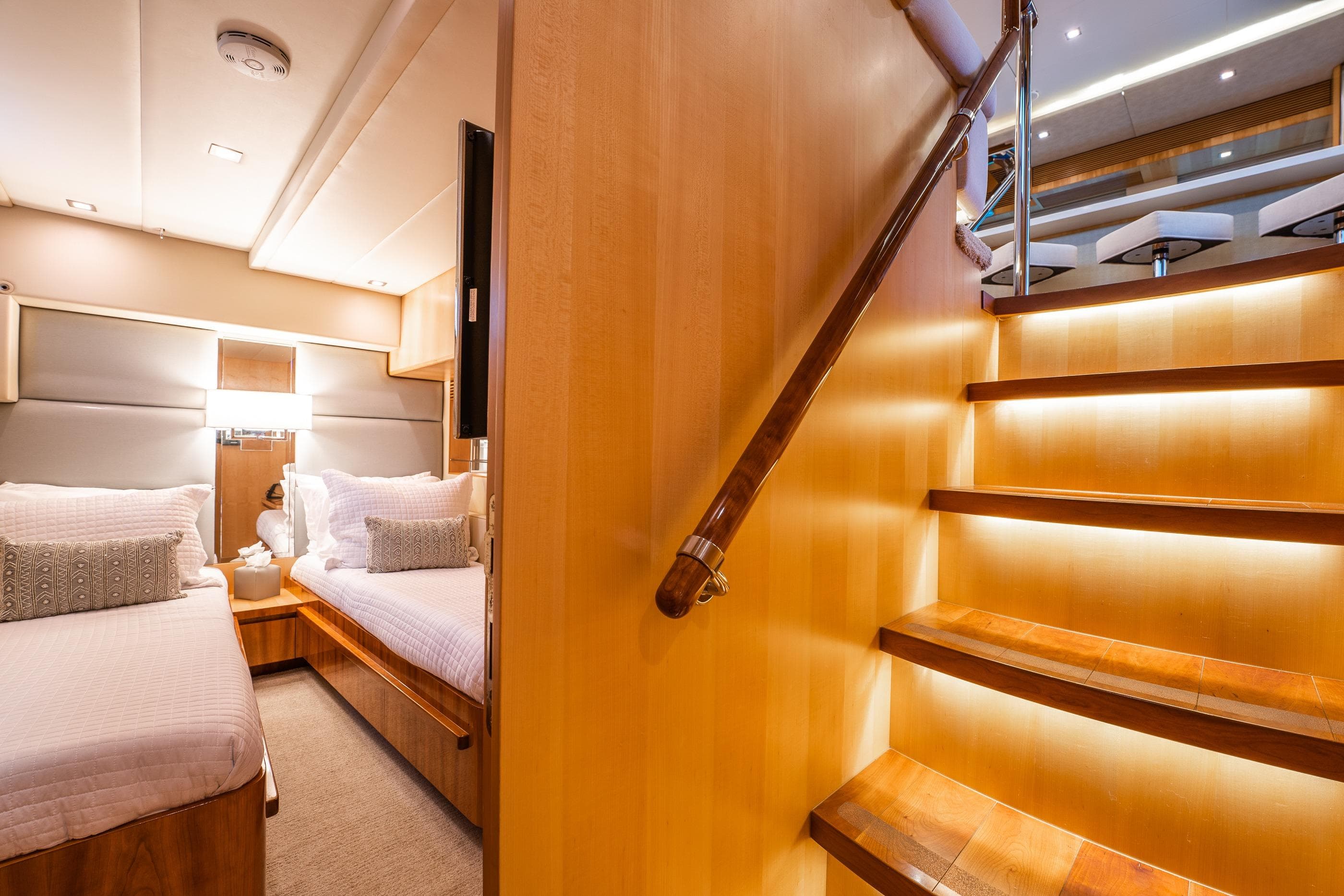 Luxurious 2013 Horizon PC60 yacht interior with cozy twin beds and elegant wooden staircase.
