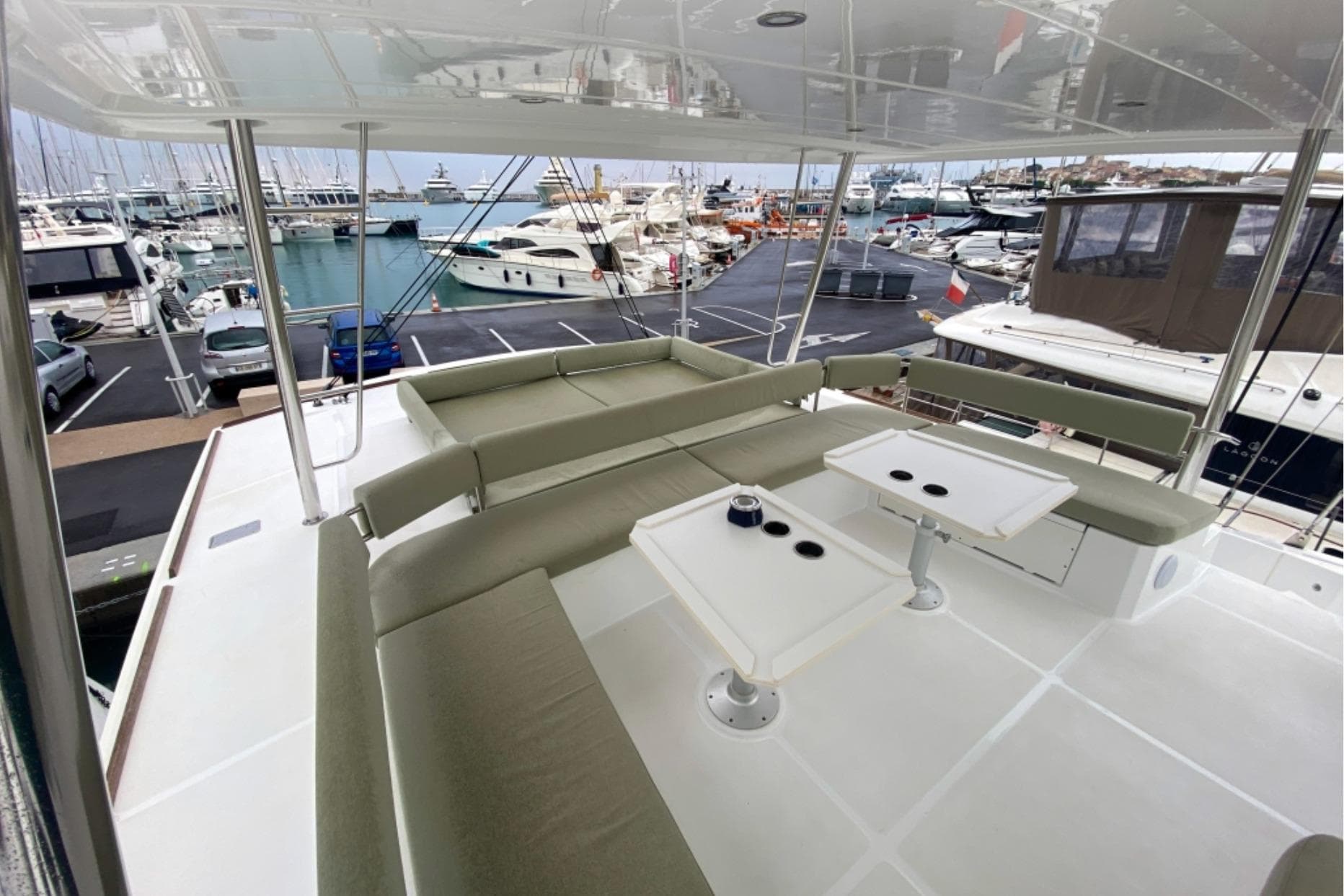 Spacious deck of 2023 Bali 5.4 yacht in marina, featuring comfortable seating and tables.