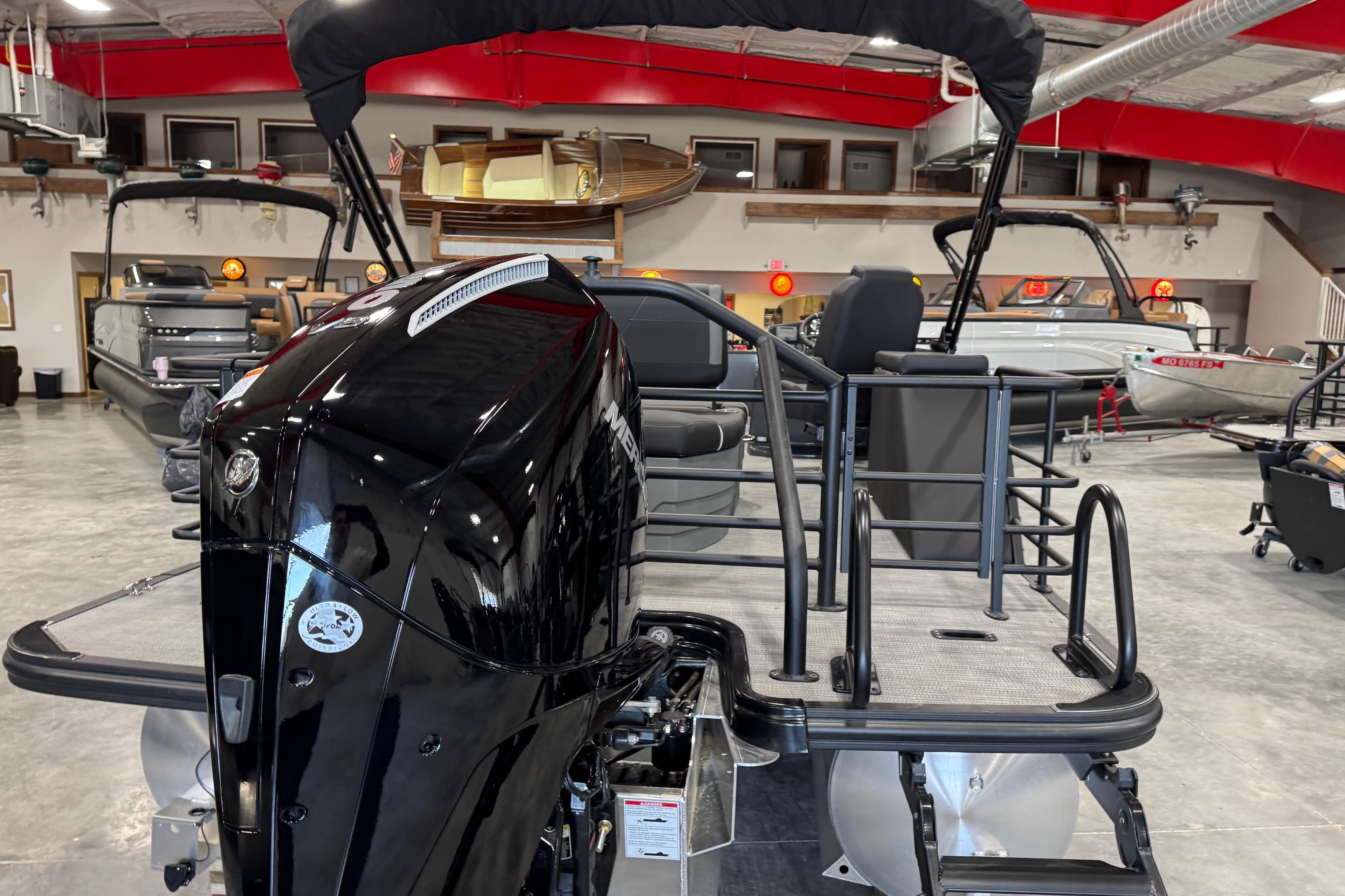 2026 Sylvan X5 boat in showroom, featuring sleek black motor and modern design.