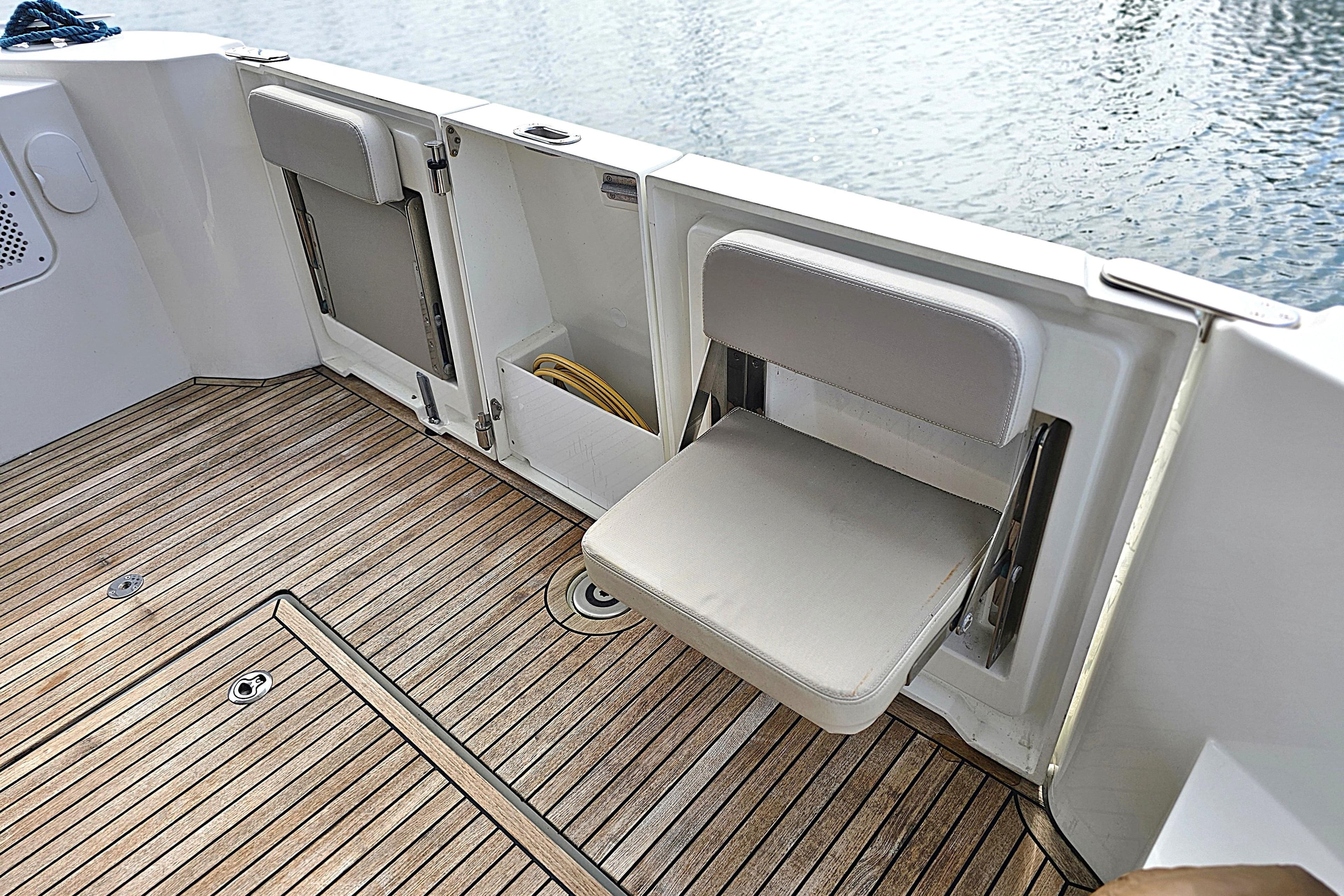 2018 Beneteau Swift Trawler 35 with foldable seats and teak deck by the water.