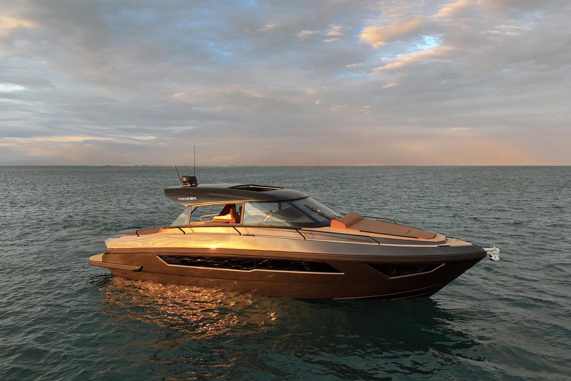 Luxurious 2025 Focus 3X yacht on tranquil ocean at sunset.
