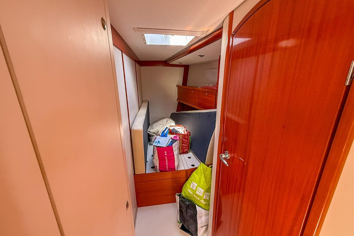 Interior cabin of 2004 Hanse 531 yacht with wooden finish and storage items.