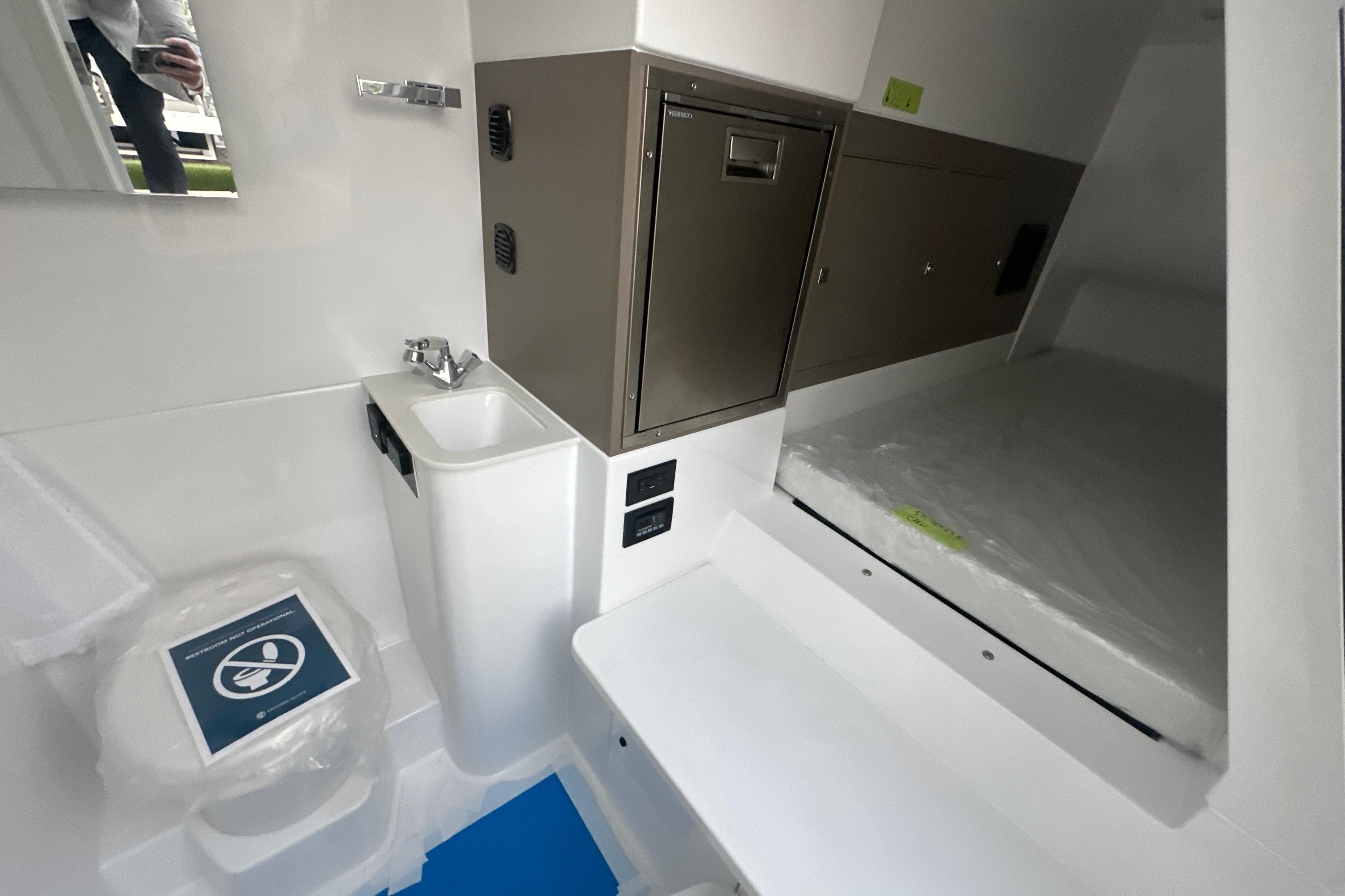 2026 Cruisers Yachts 57 Fly interior with compact bathroom and storage.