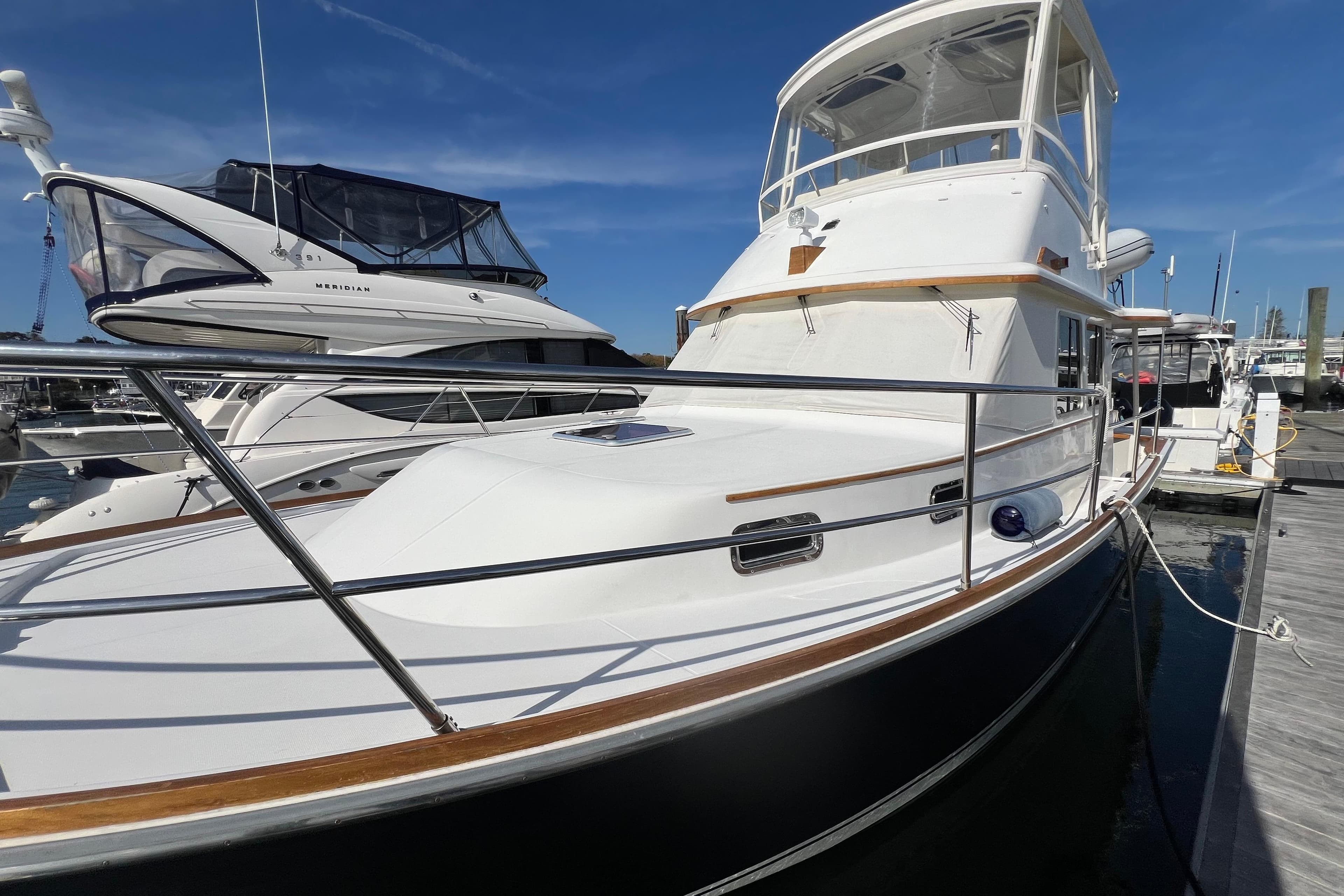 2005 Sabre Flybridge yacht docked at marina under clear blue sky.