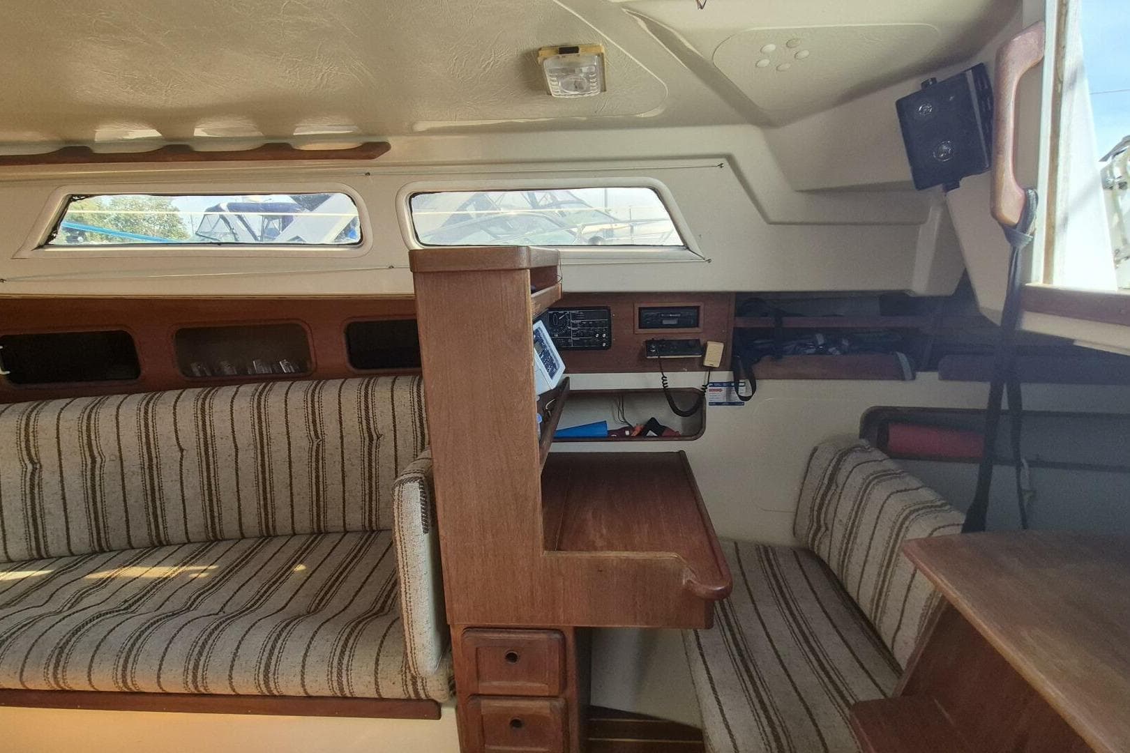 Interior of 1984 Mirage Yachts 35, featuring striped seating and wooden cabinetry.