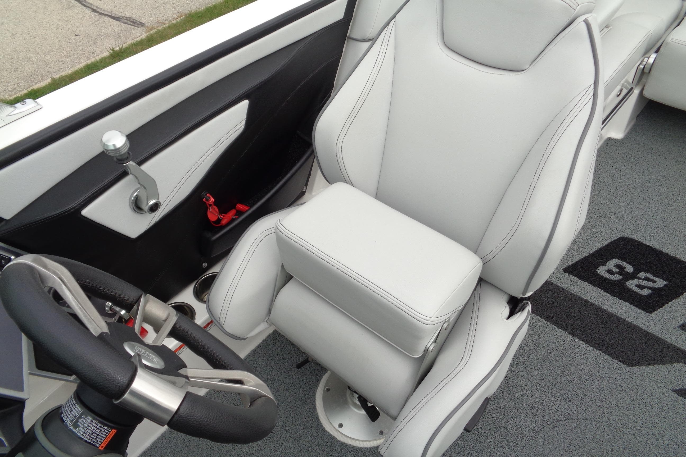 2020 MasterCraft XT23 boat interior with sleek white captain's seat and steering wheel.