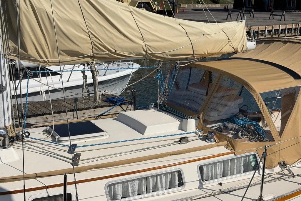 1984 Sabre 34-1 sailboat with beige canvas cover docked at marina.