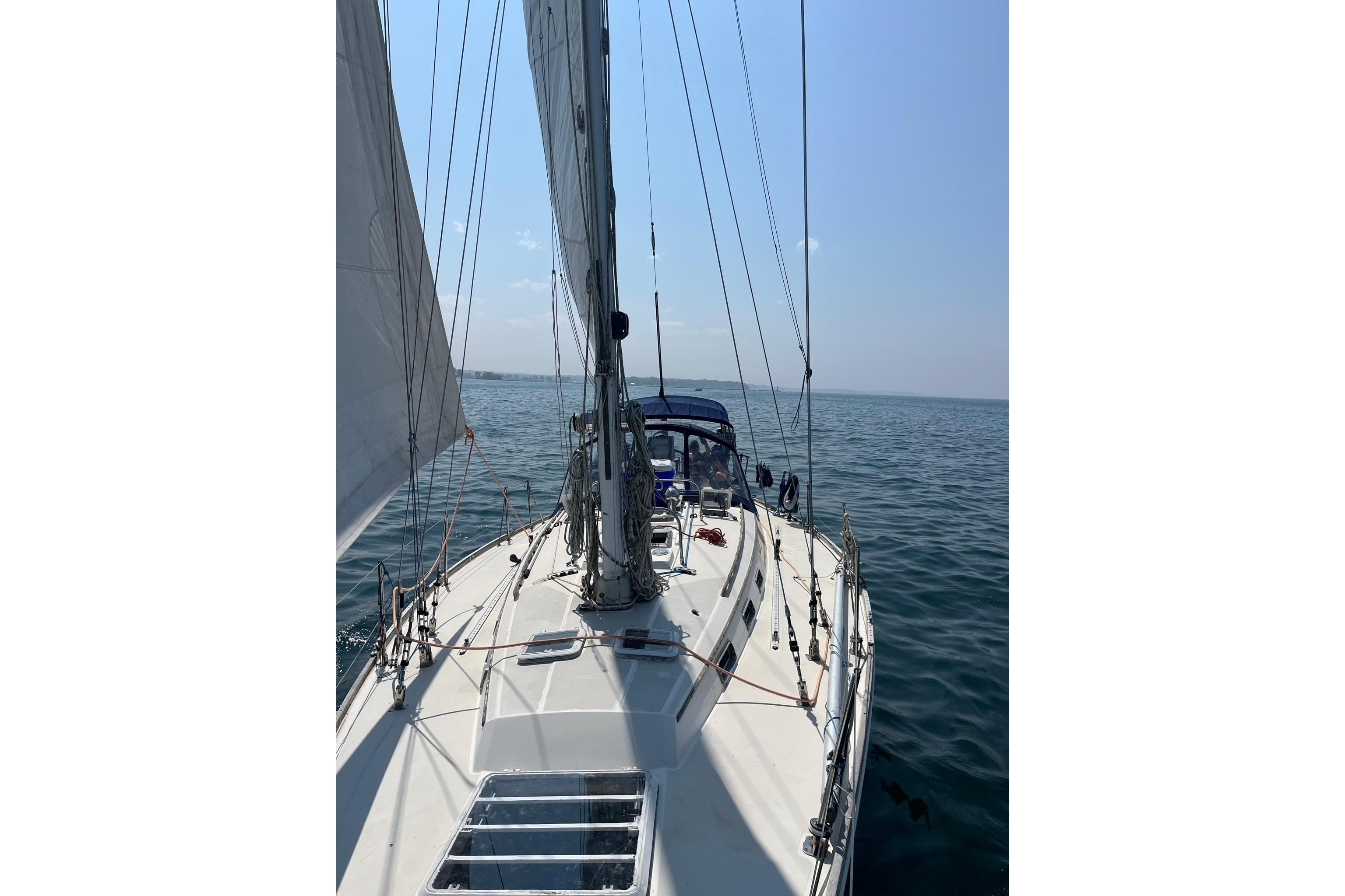 Sailing on a 1987 Sabre 42 yacht in open waters under clear skies.