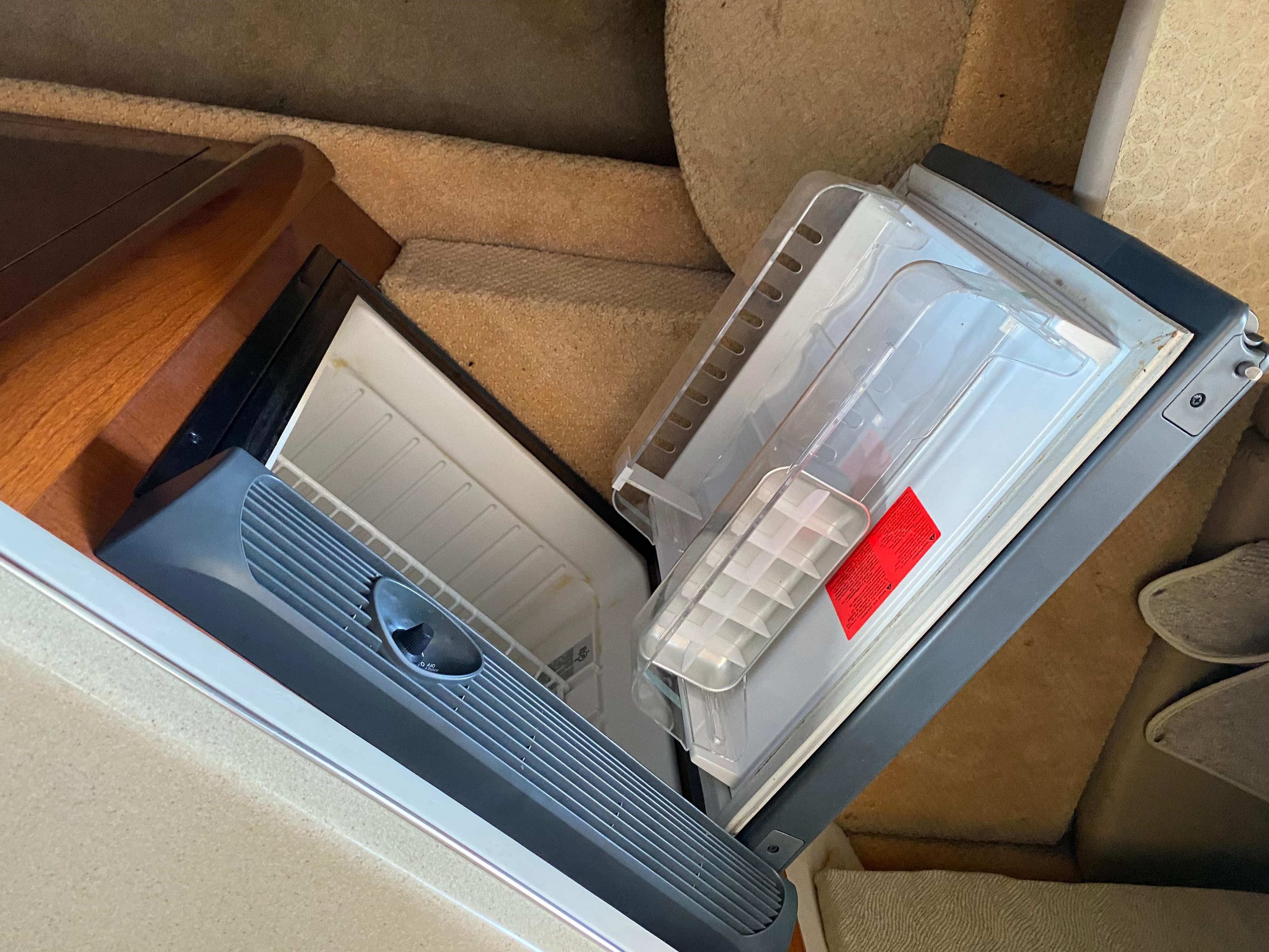 Open refrigerator inside 2008 Sea Ray 270 Amberjack boat cabin.