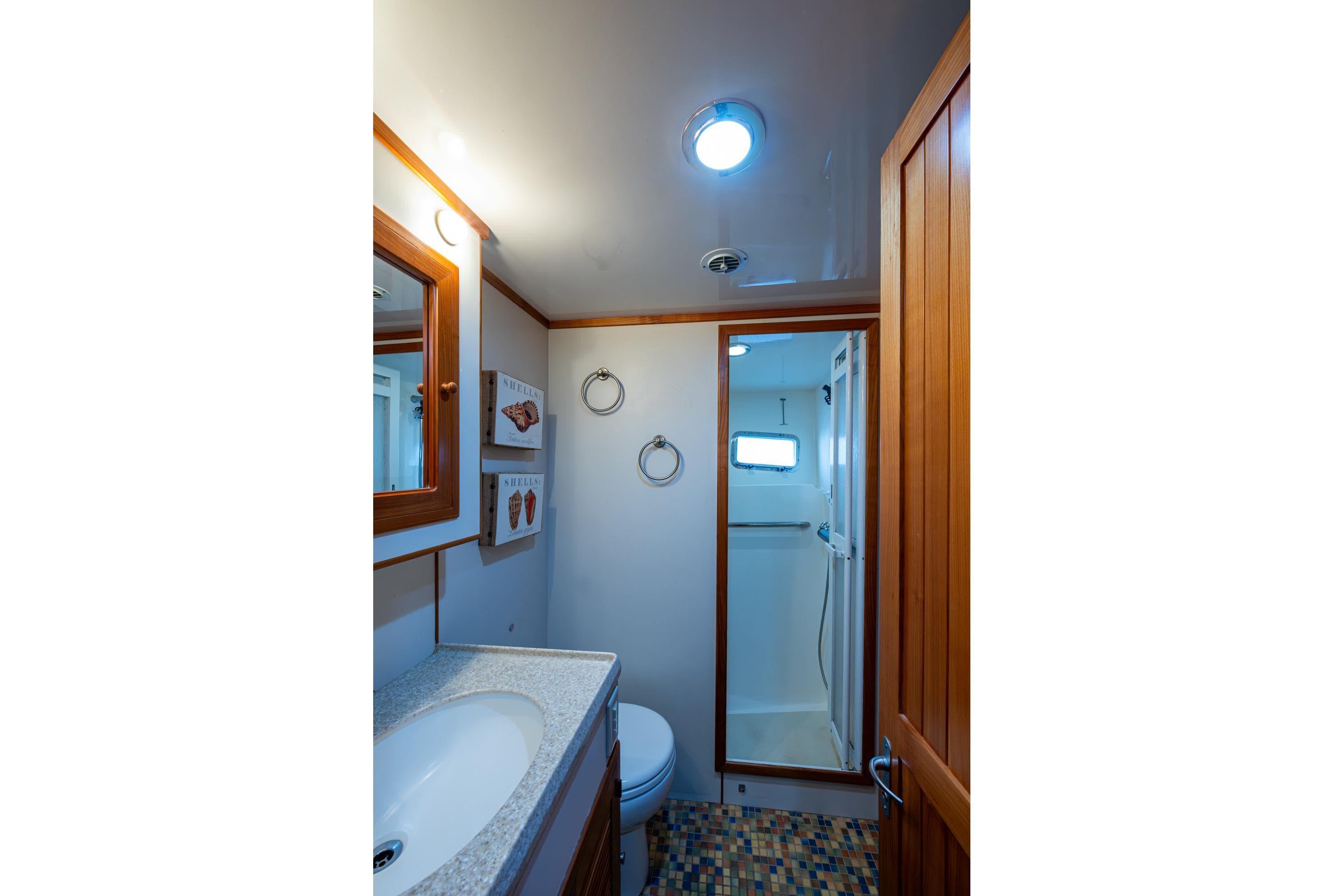 Bathroom interior of 2006 Krogen 58 yacht with shower and wooden accents.