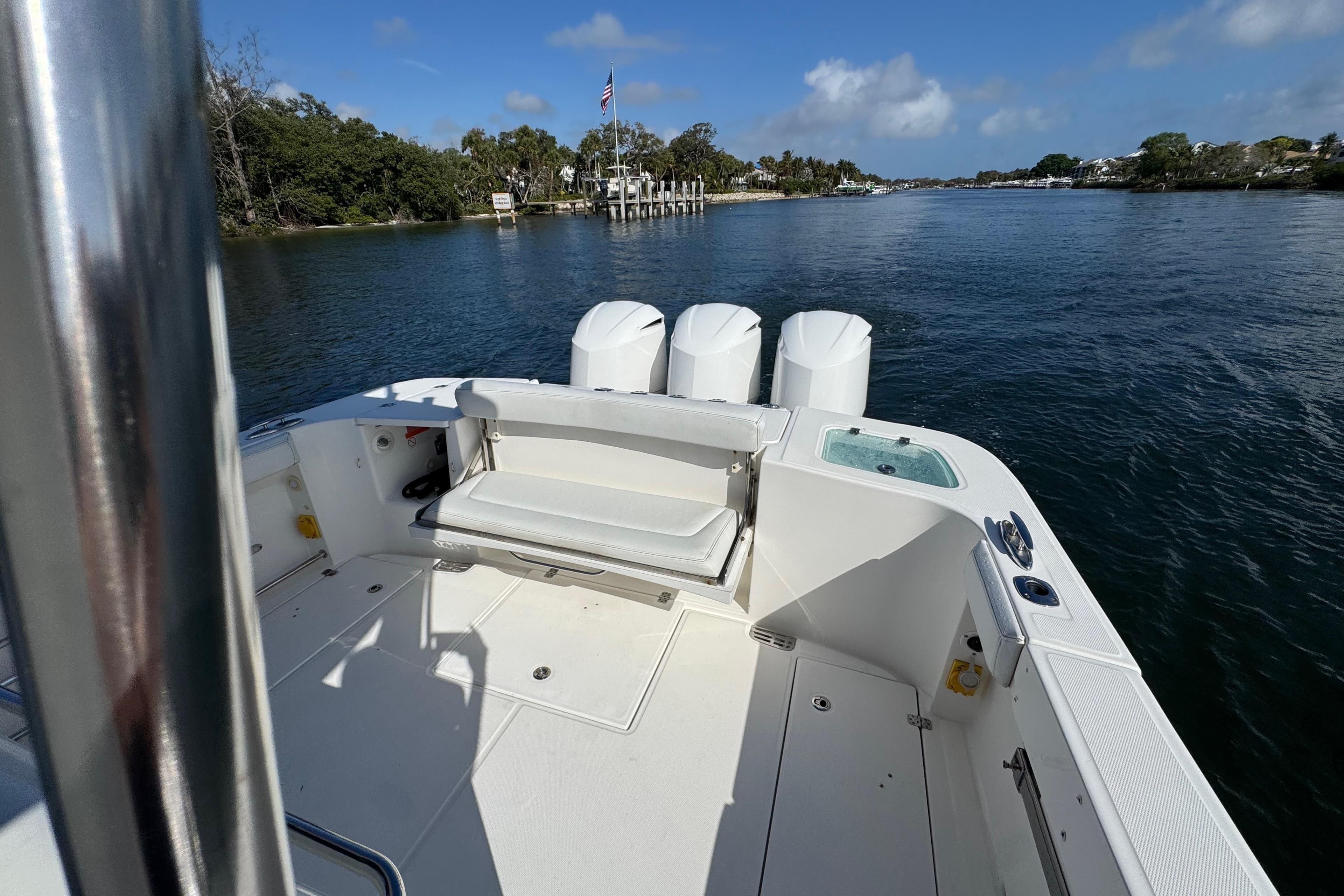 2017 Edgewater 368CC boat on calm water, featuring spacious deck and triple engines.
