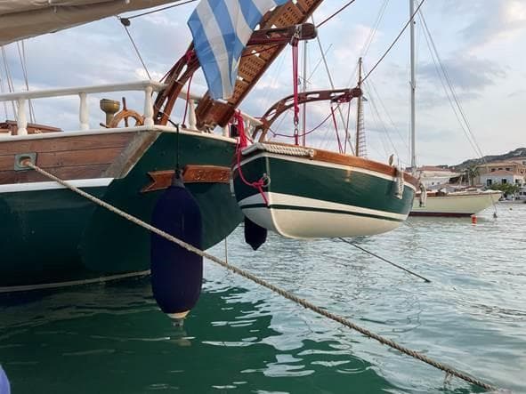 A 1966 Canadian gaff rigged whaler schooner docked, featuring classic wooden design and vibrant colors.