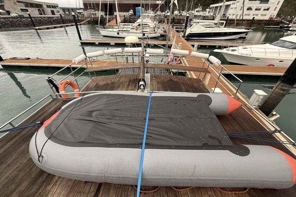 23m Custom Sloop (2012) docked with inflatable boat on deck, marina background.
