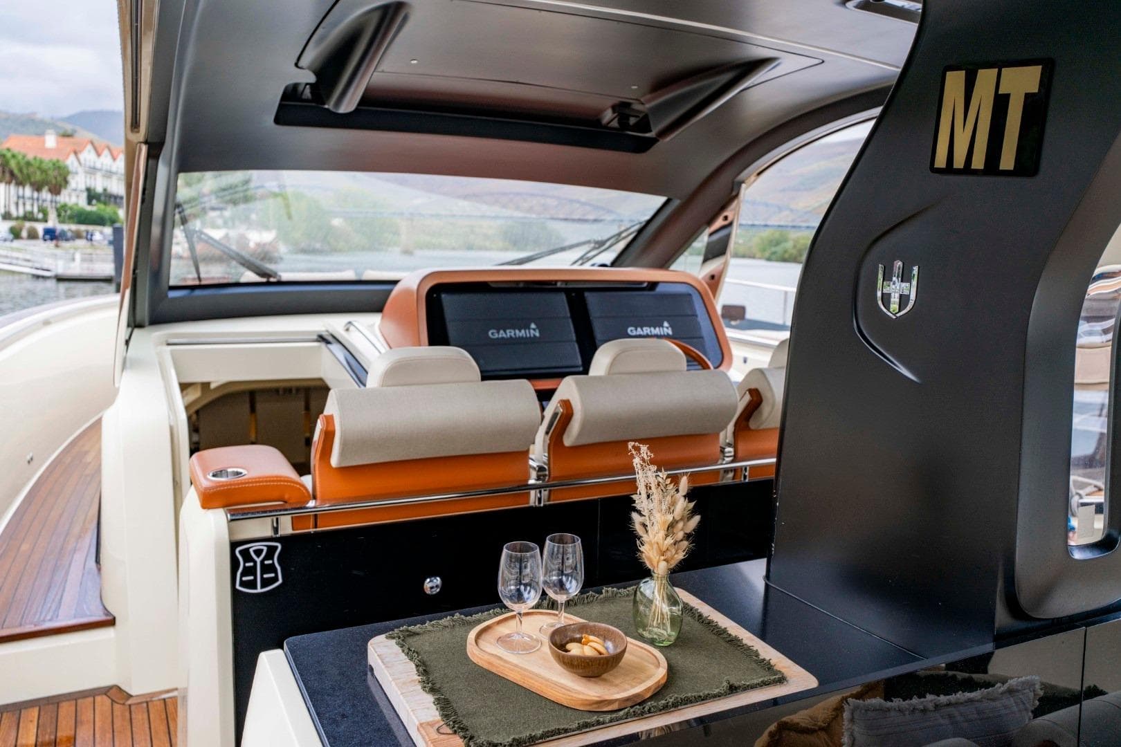 Luxurious interior of 2022 Invictus TT460 yacht with elegant seating and navigation displays.