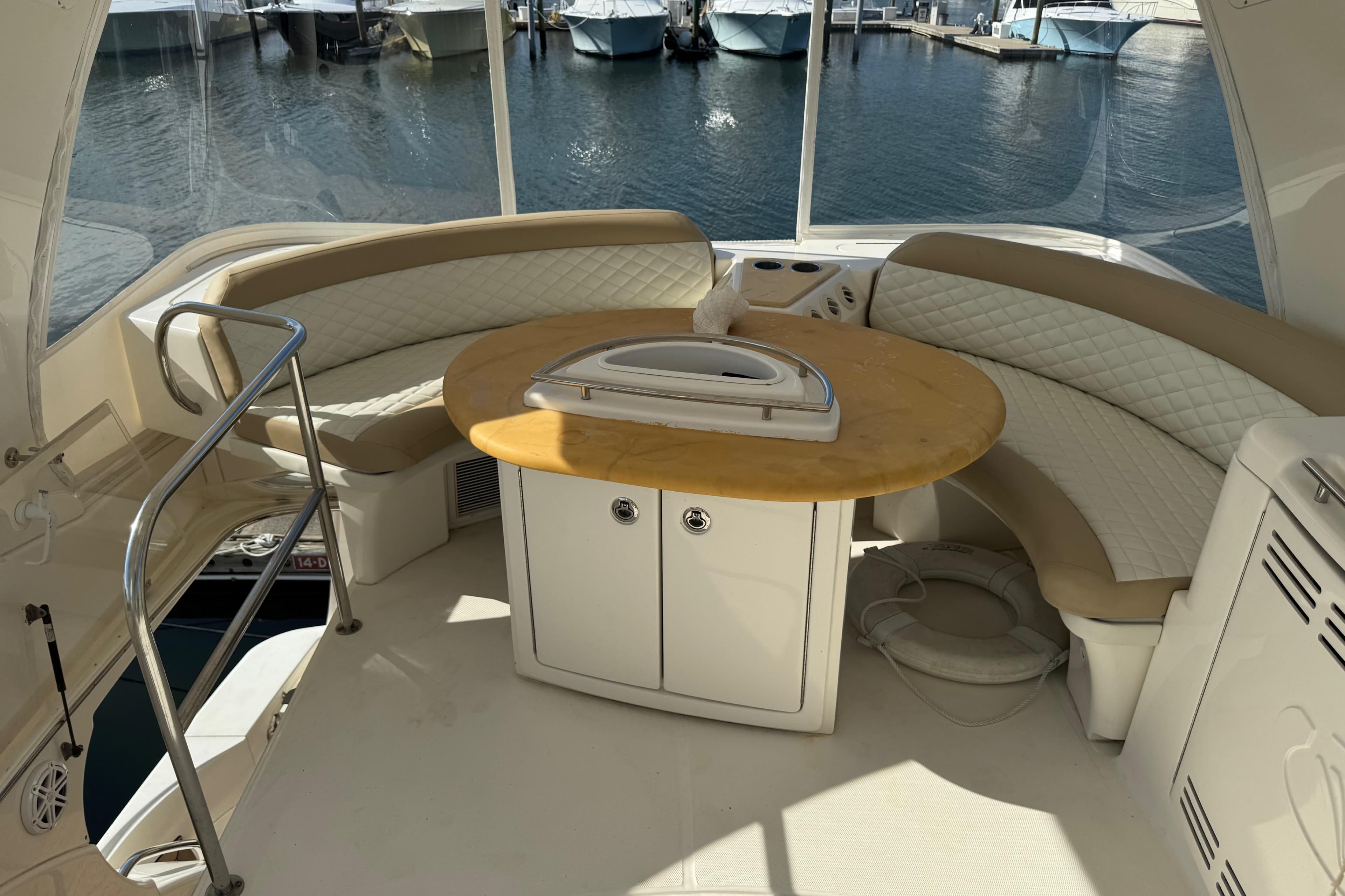 Luxurious 2009 Ovation 52 yacht interior with curved seating and round table.