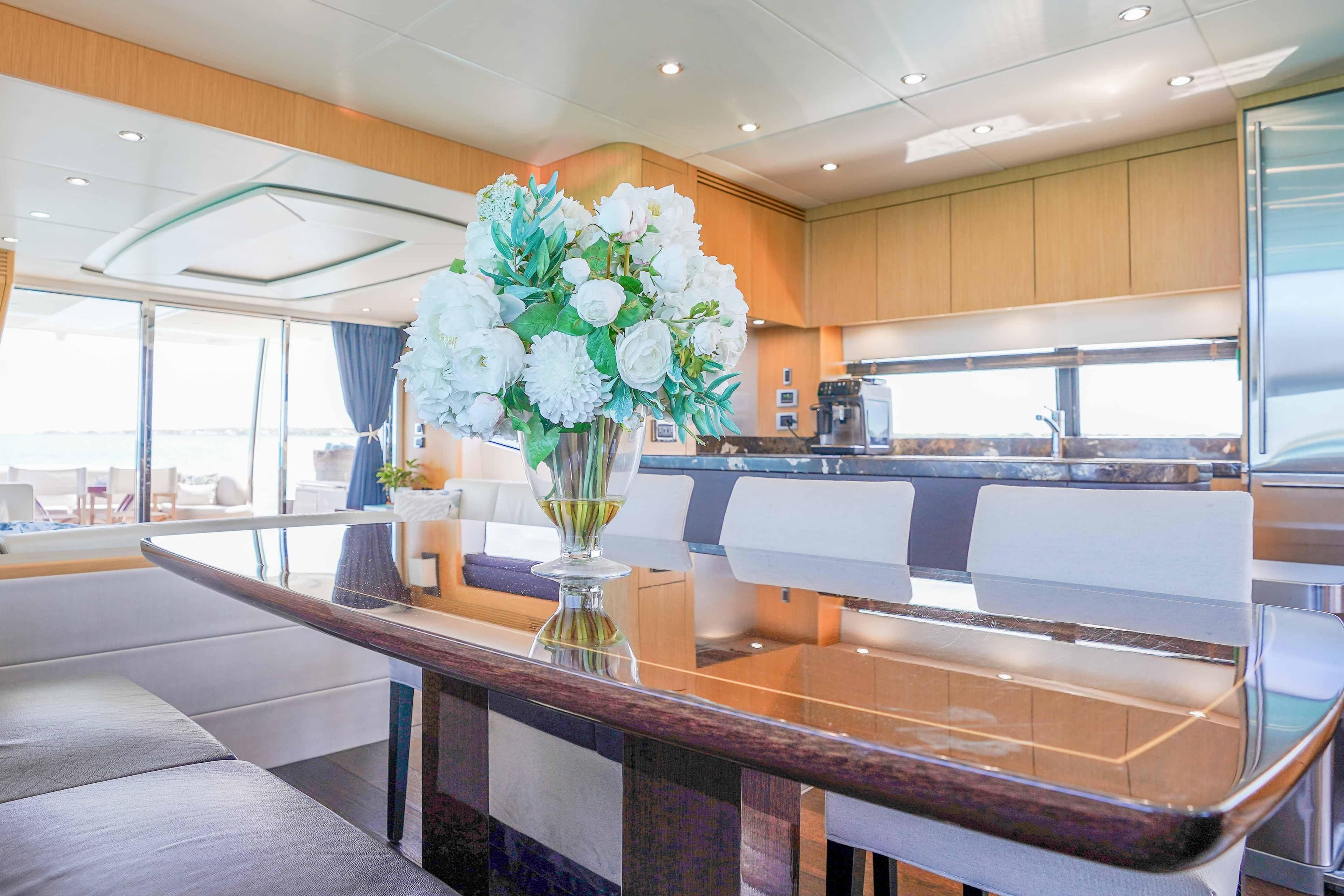 Luxurious interior of 2016 Sunseeker 75 Yacht with elegant dining area and floral centerpiece.
