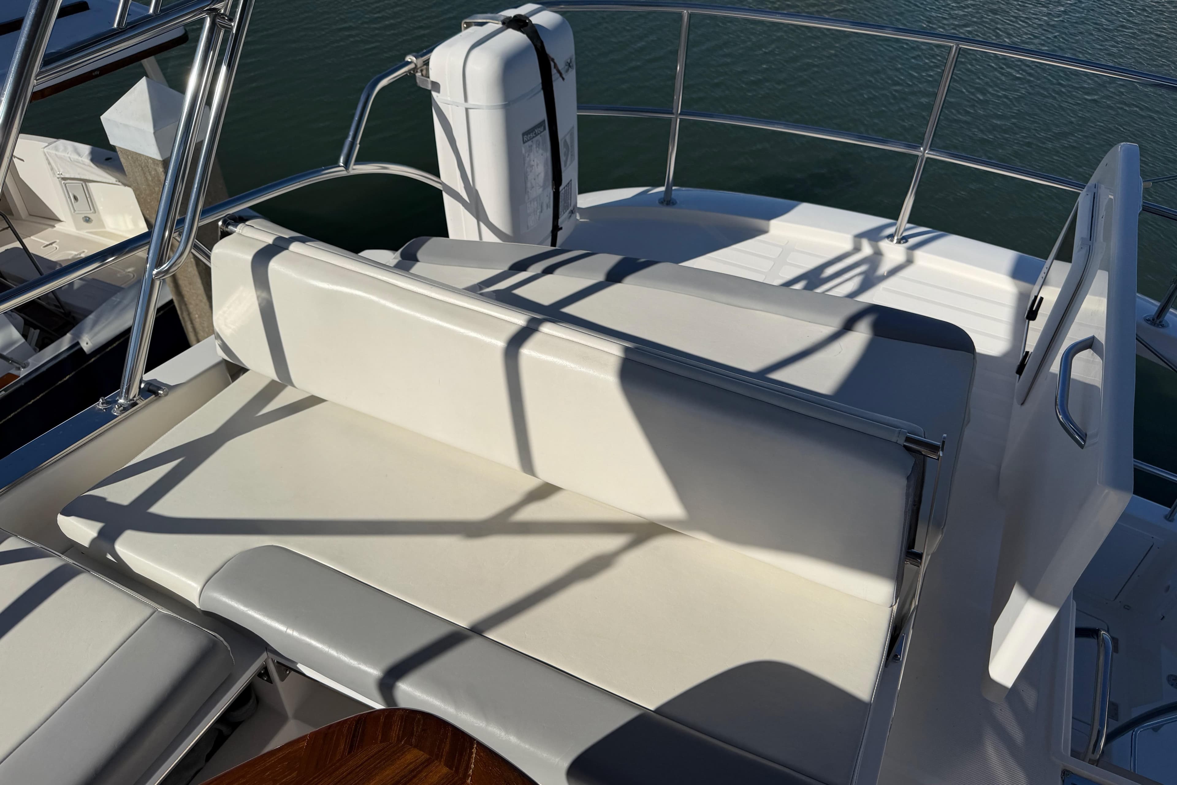 Aspen C120 2017 boat seating area with white cushions and stainless steel railings.