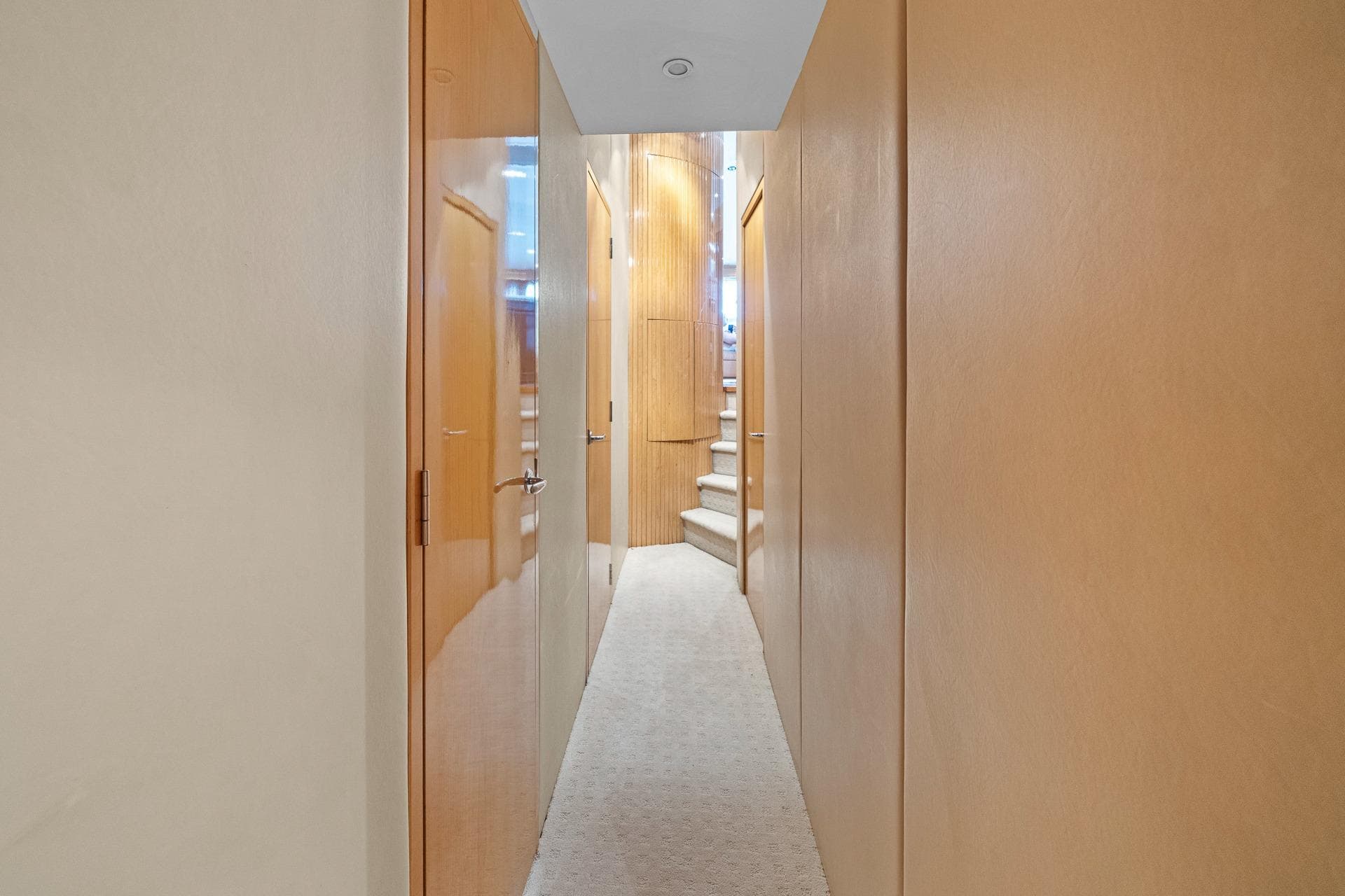 Interior hallway of 2002 Hatteras 60 Convertible yacht with wooden doors and carpeted floor.