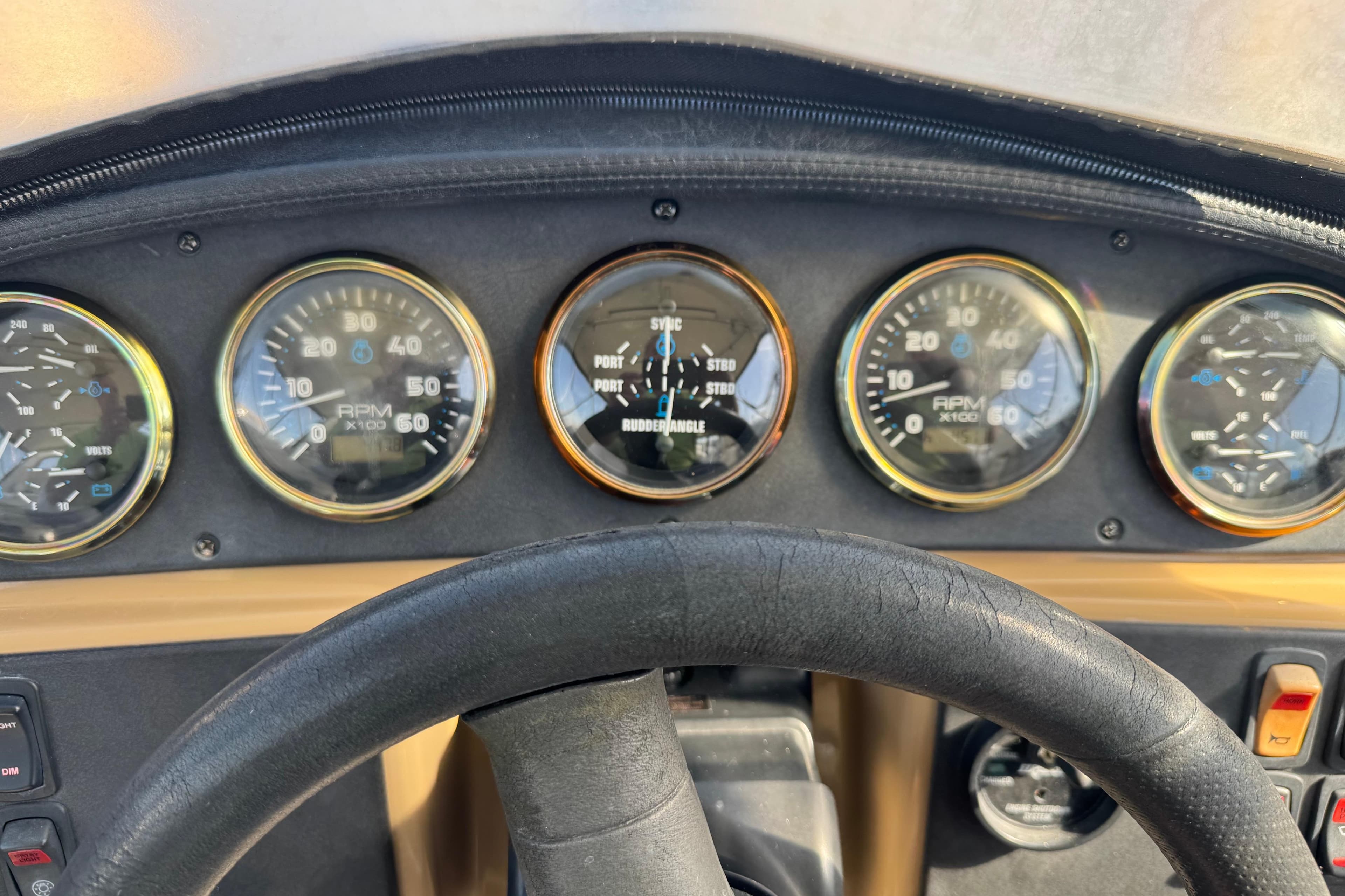 Dashboard of a 2004 Carver 396 Motor Yacht with gauges and steering wheel.