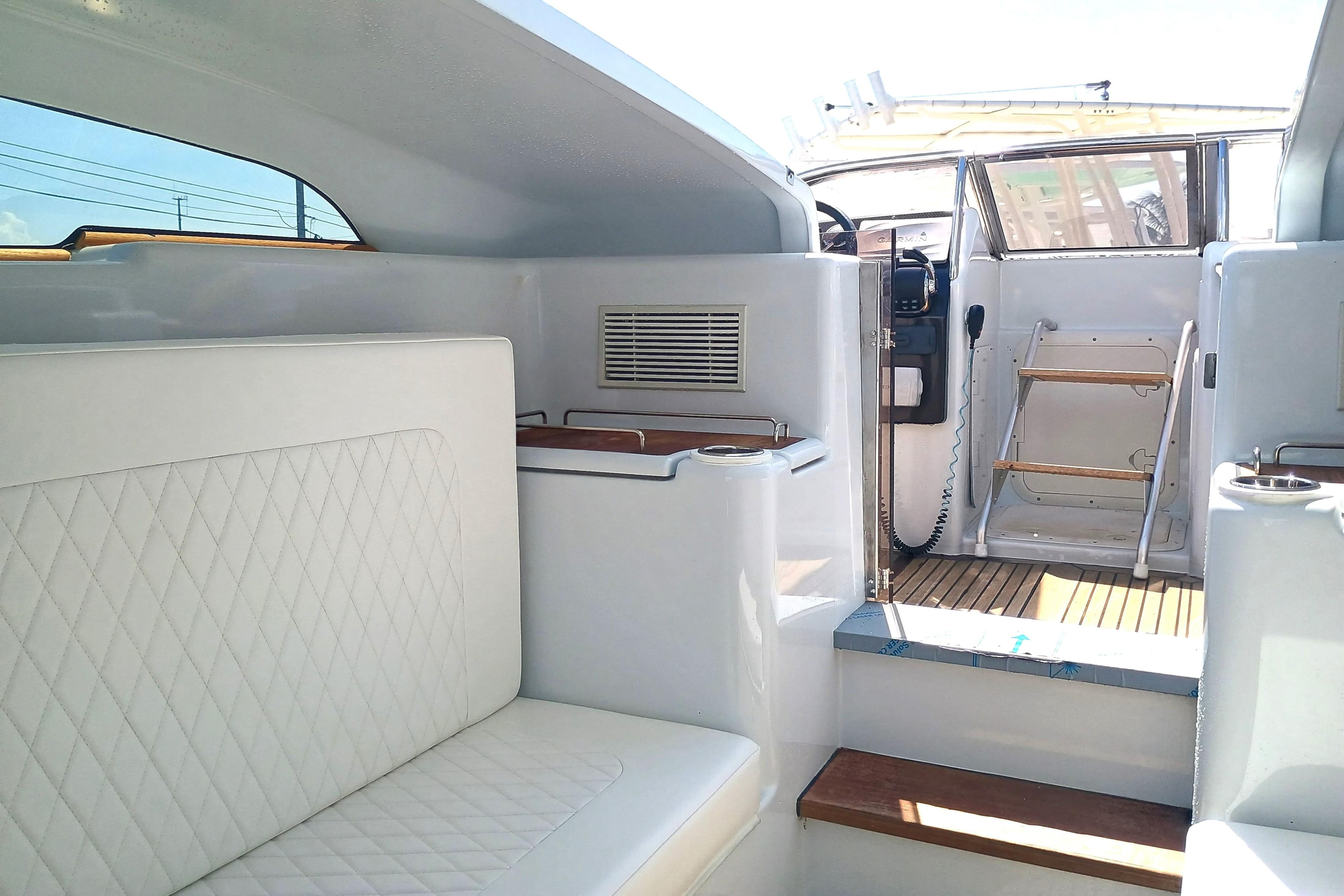 Interior of 2006 Royal Denship Royal Limo yacht with white seating and wooden accents.