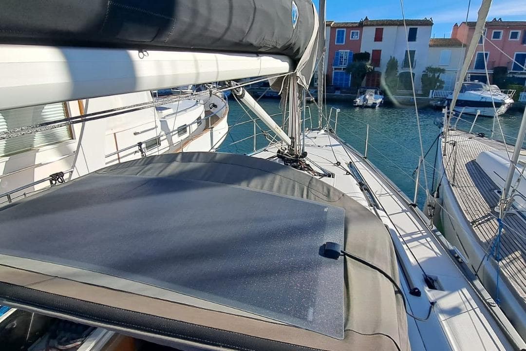 2019 Salona 380 sailboat docked in a marina, surrounded by colorful buildings.