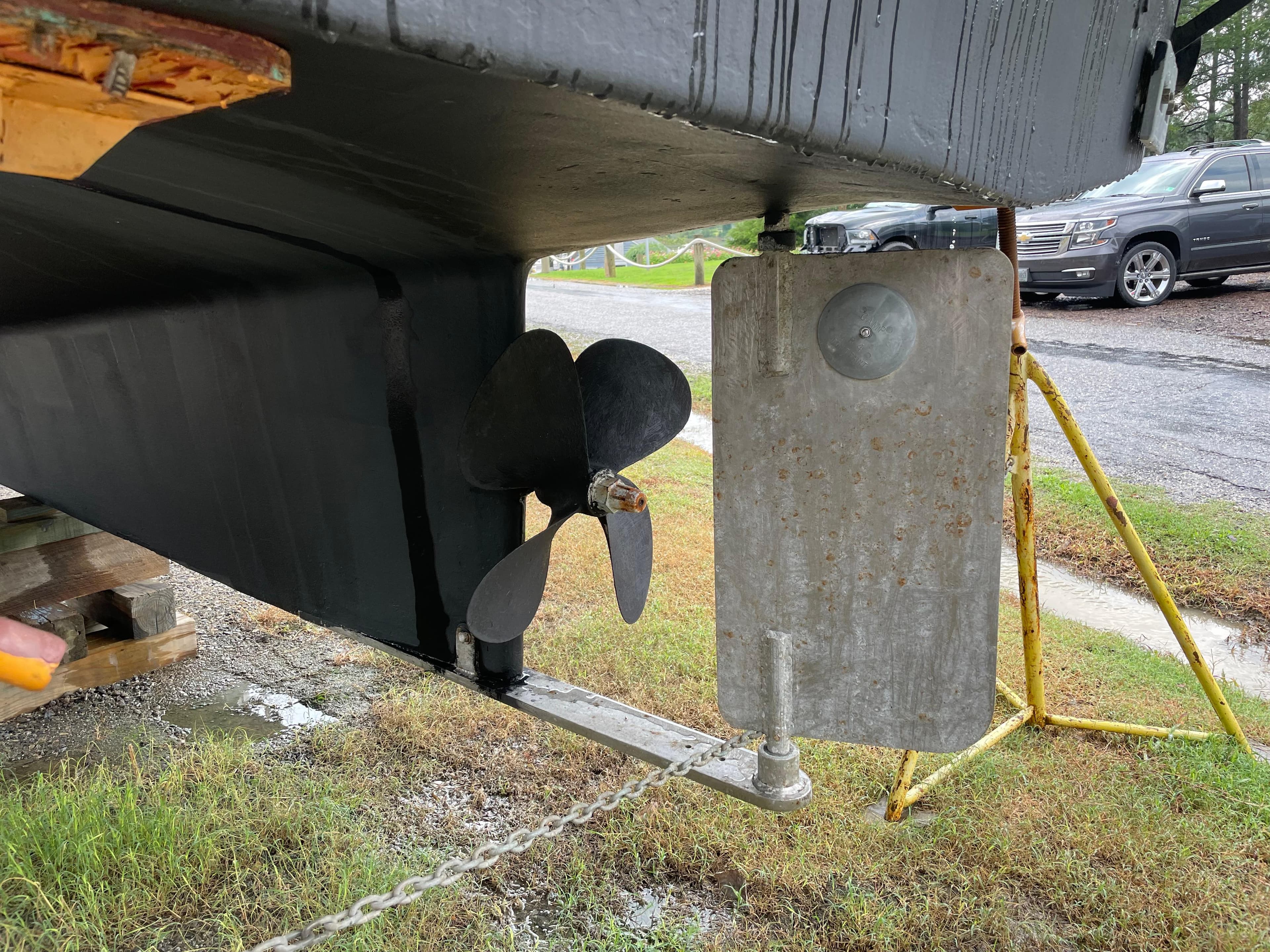 1998 Nordic Tug 32 propeller and rudder detail, displayed on a stand outdoors.
