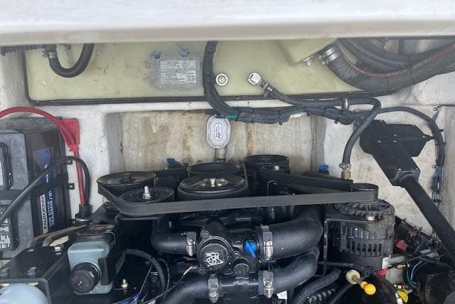 Engine compartment of a 2015 Rinker 276 Captiva Cuddy boat, showcasing mechanical components.