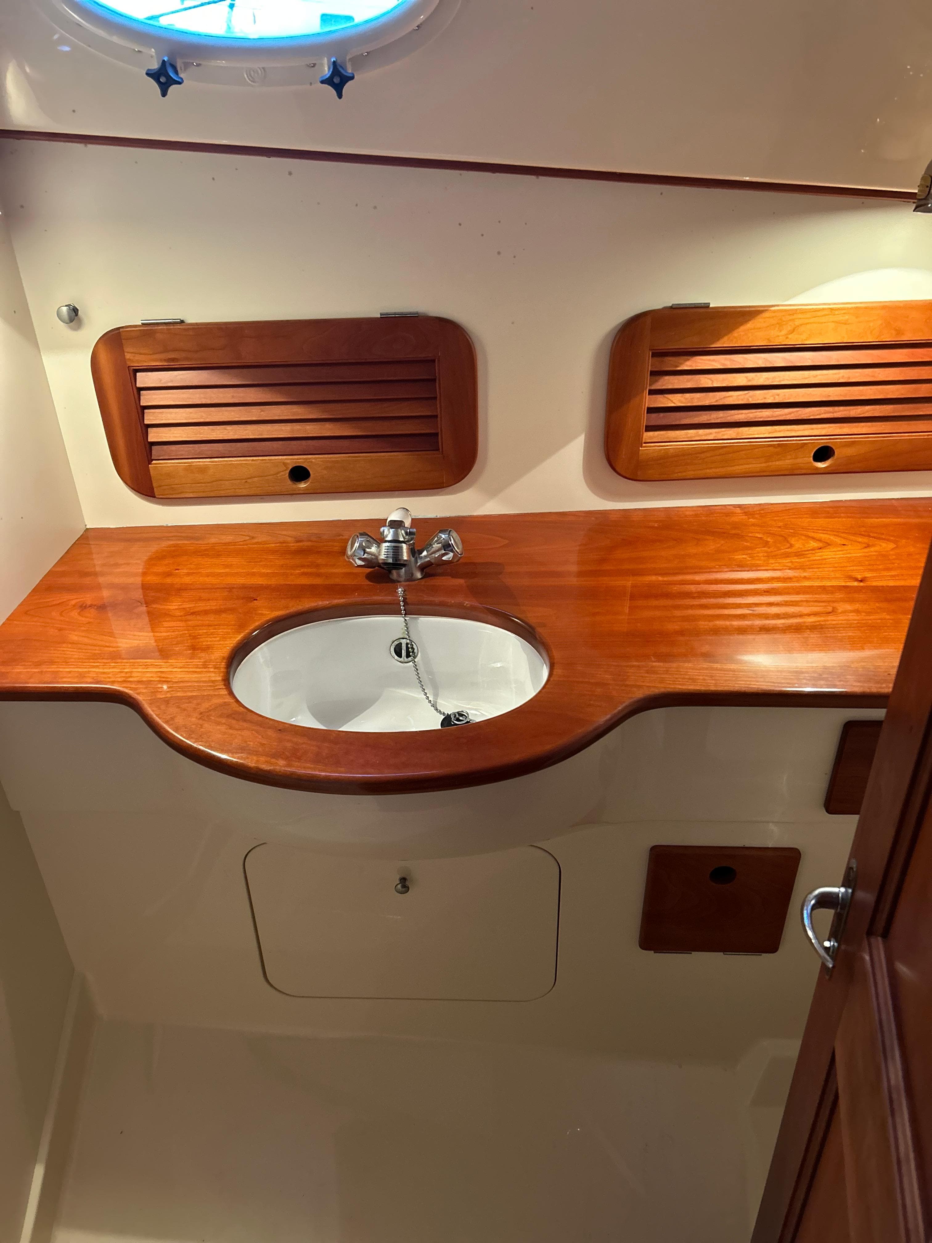 2001 Hinckley Classic 36 Picnic Boat interior with wooden sink area and storage.