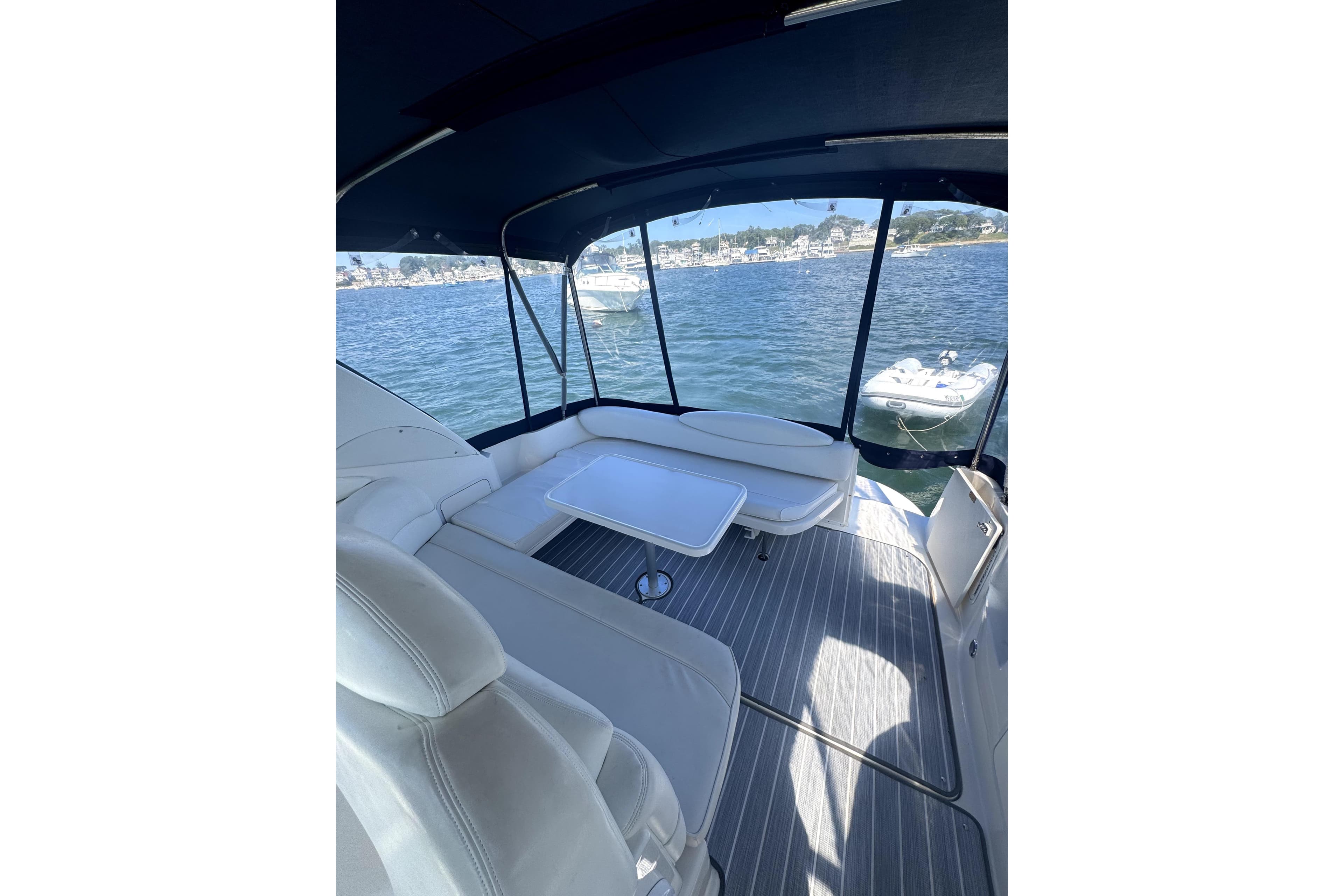 2002 Sea Ray 340 Sundancer boat interior with seating and table, overlooking calm waters.