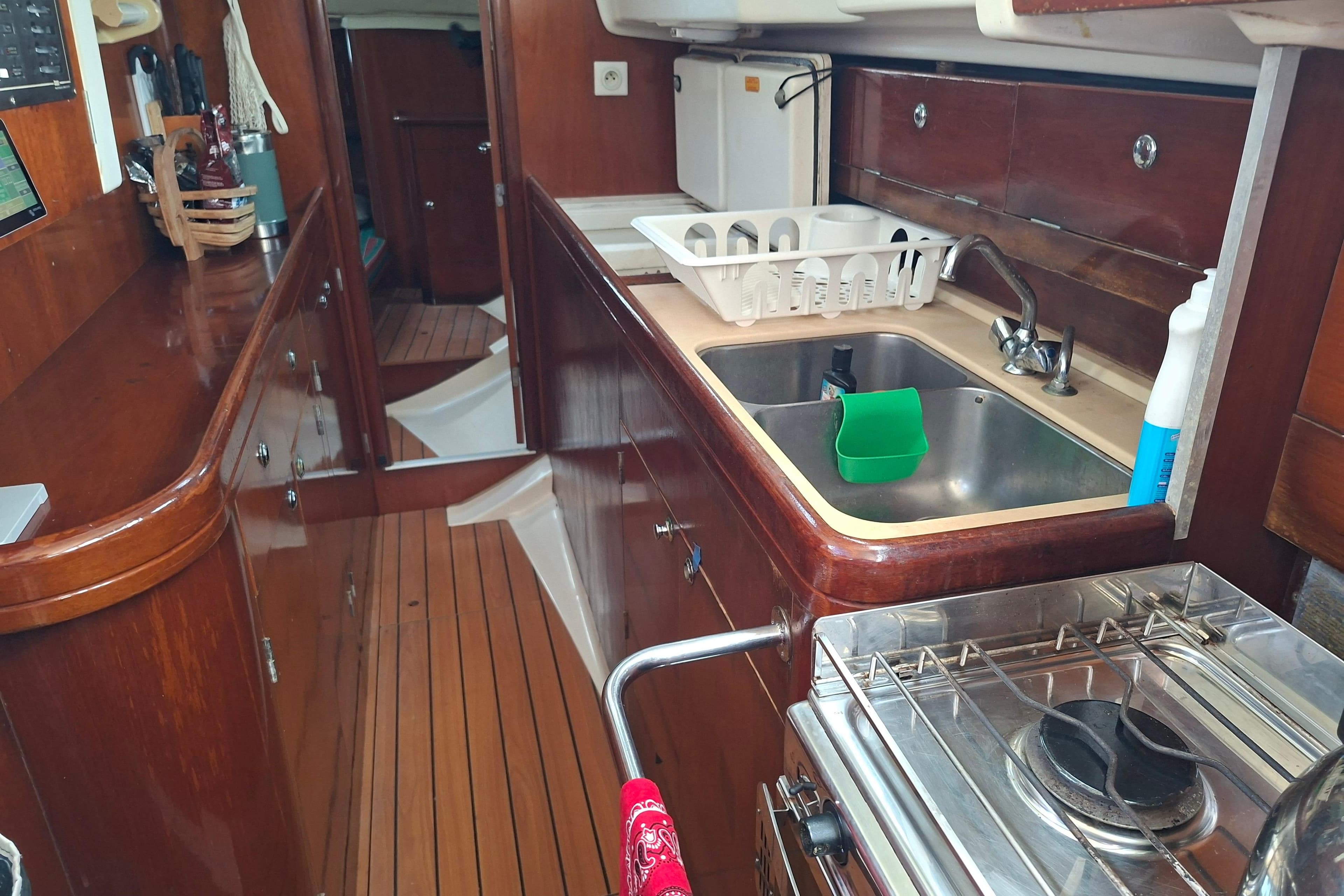 Interior of 1999 Beneteau Oceanis 40 CC yacht, featuring a compact kitchen area.