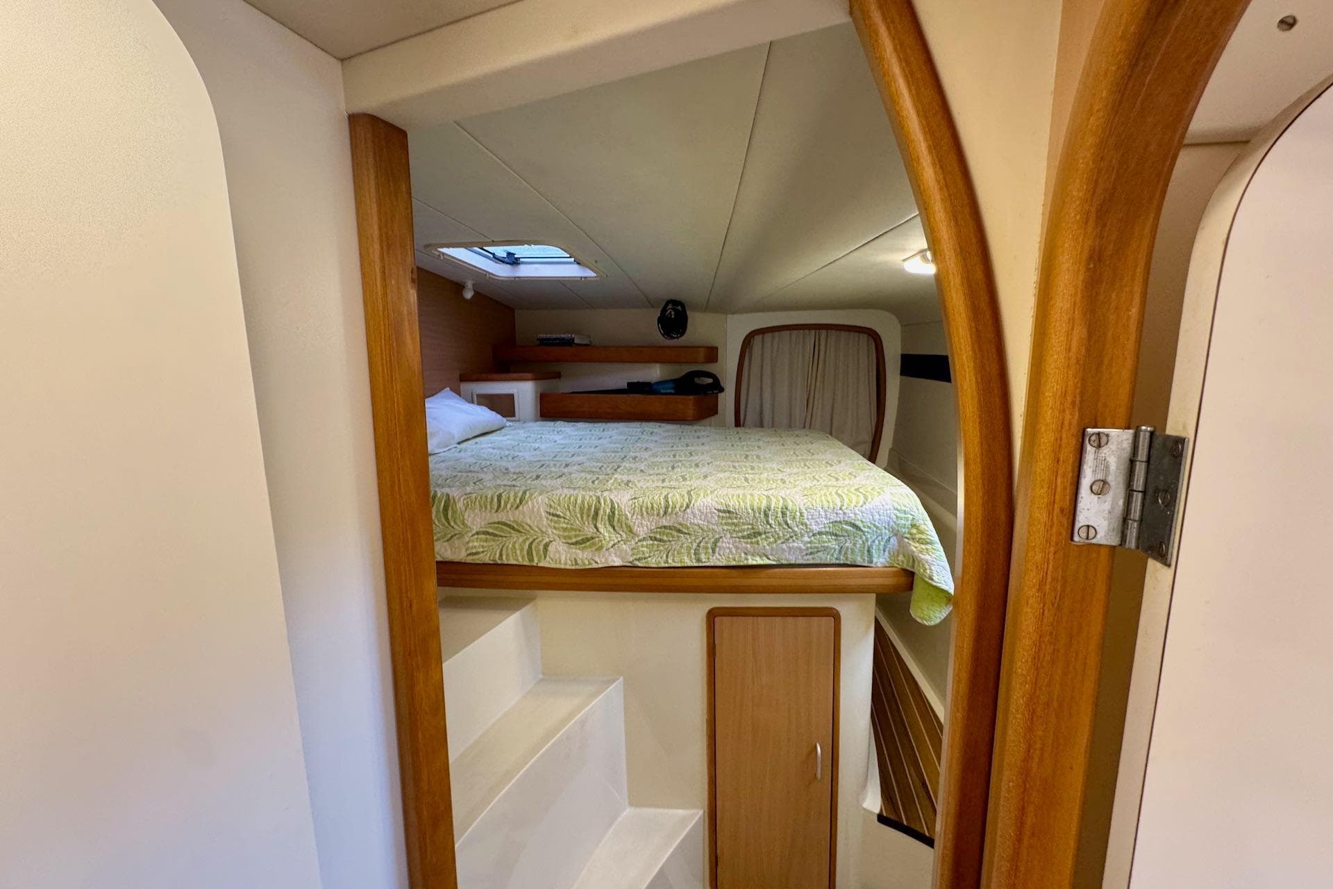 Cozy cabin interior of 2004 Leopard 42 yacht with bed and wooden accents.