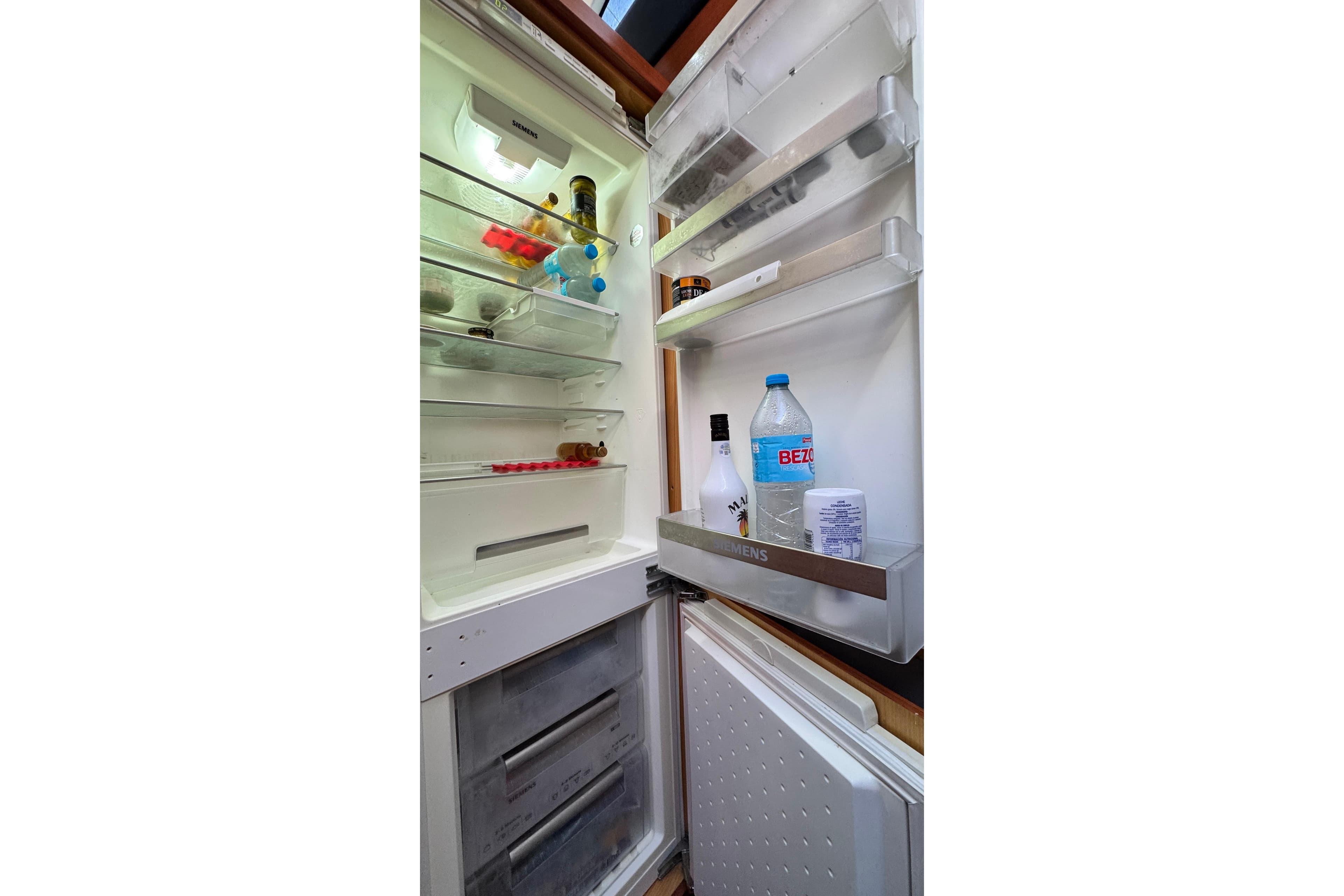 Open Doma 5 refrigerator, partially stocked with beverages and condiments, 2007 model.